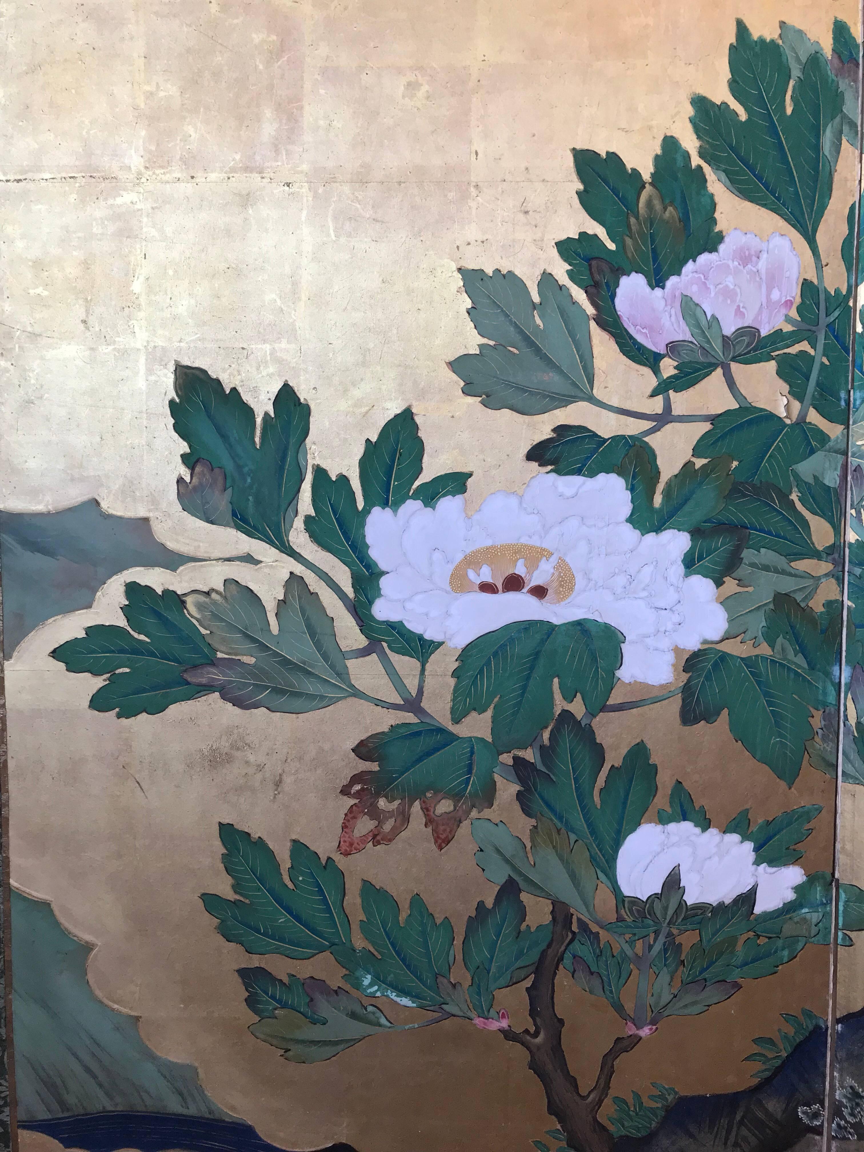 A Japanese four-panel screen with large scale peony blossoms, bamboo, and cherry blossoms on a gold leaf background.