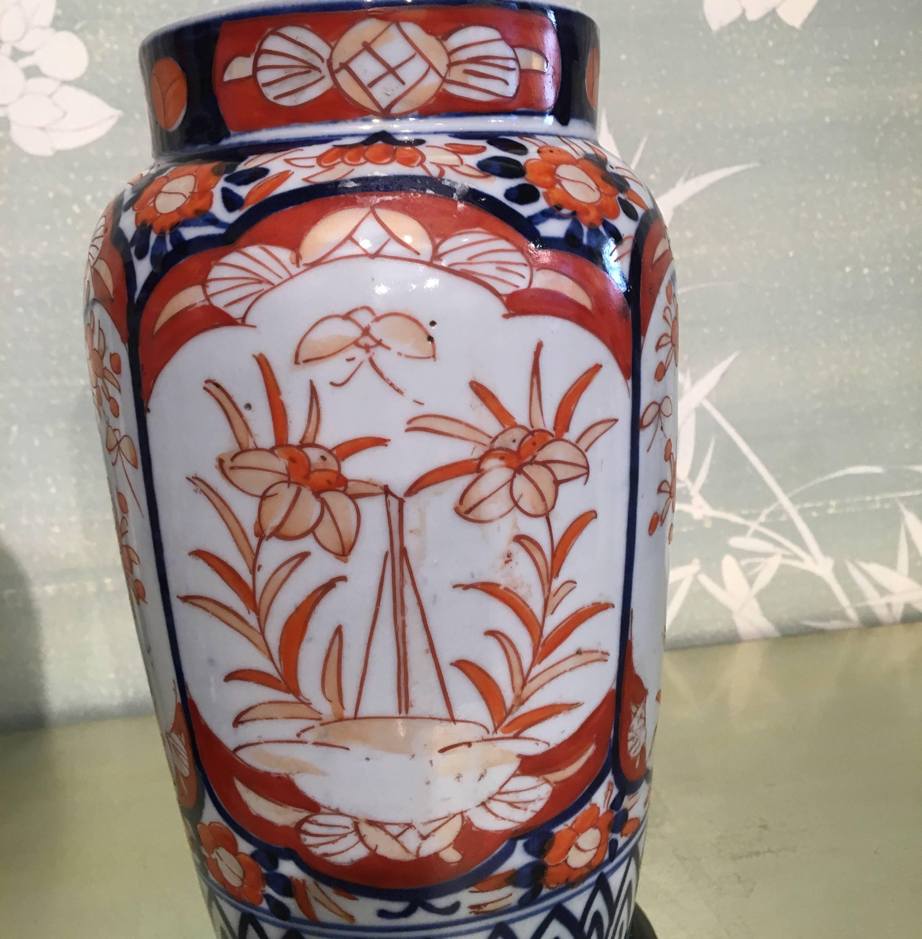 A pair of late 19th century Japanese Imari vases on stands, with design of flowering trees in reserves.