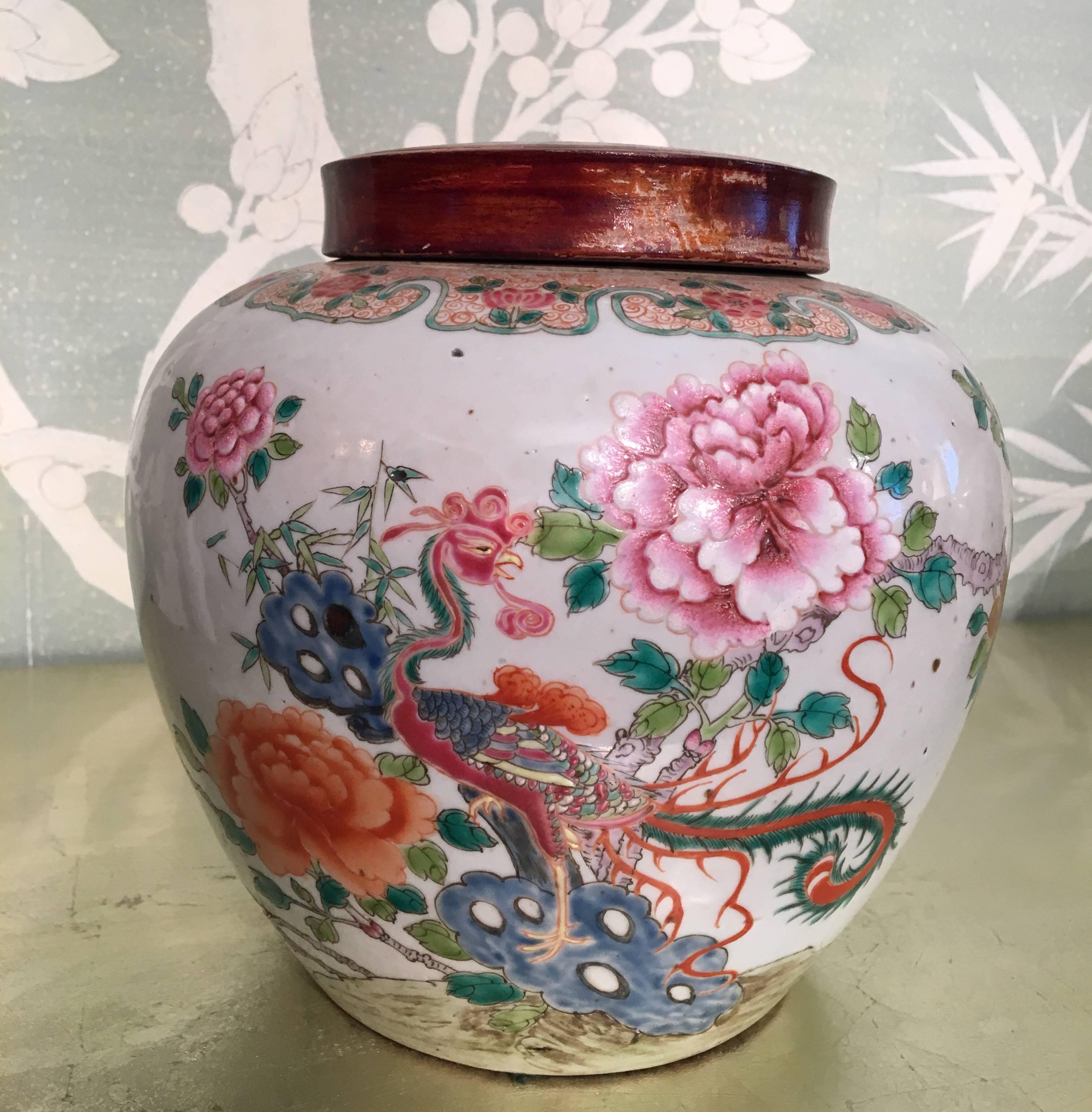 A pair of late 19th century Chinese famille rose ginger jars with design of phoenix and peonies. Jars with wooden lids.