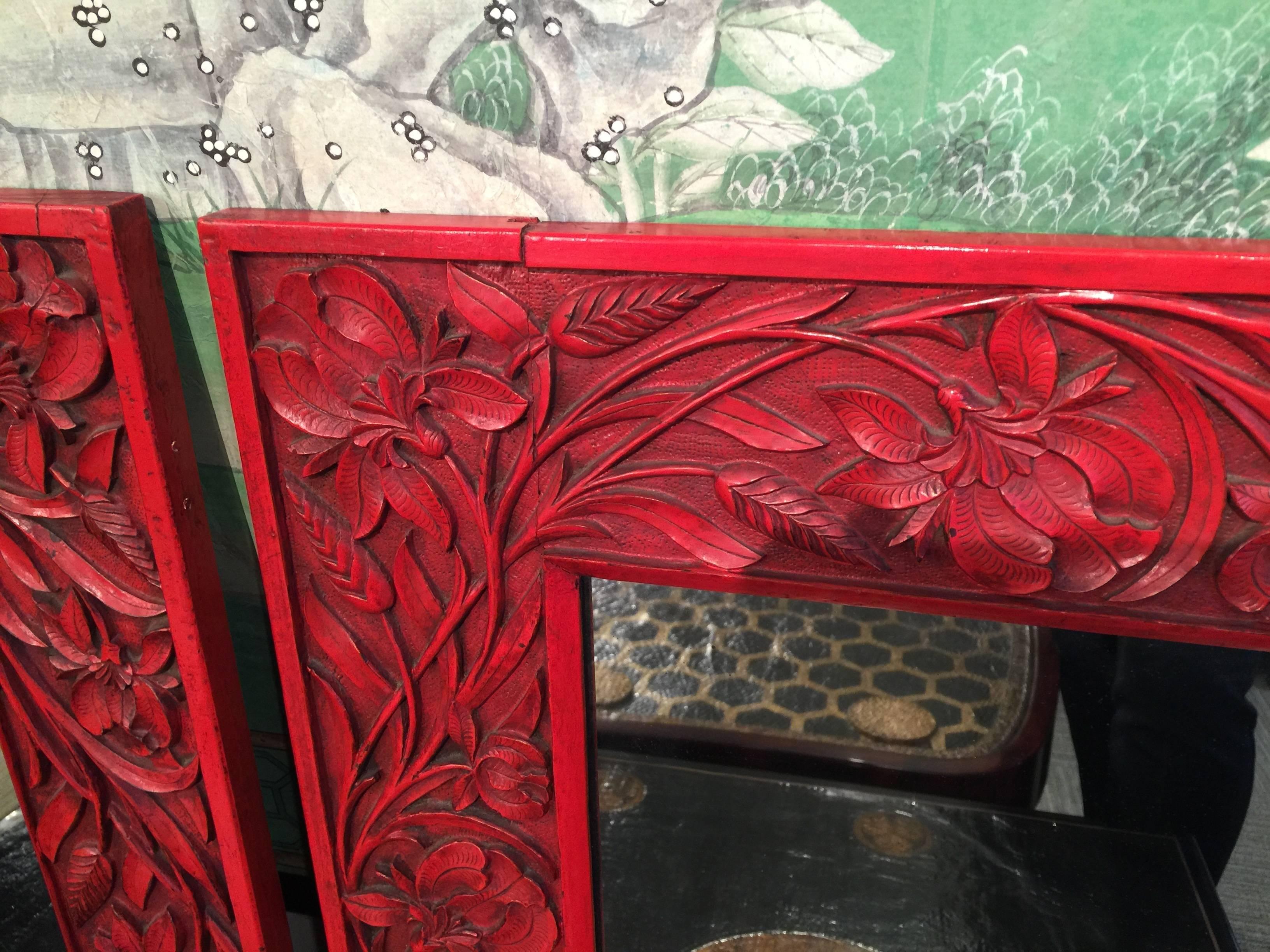 A beautiful pair of intricately carved mirrors.

Very detailed floral design, with red lacquer finish.

Hanging hardware is on the back of each.