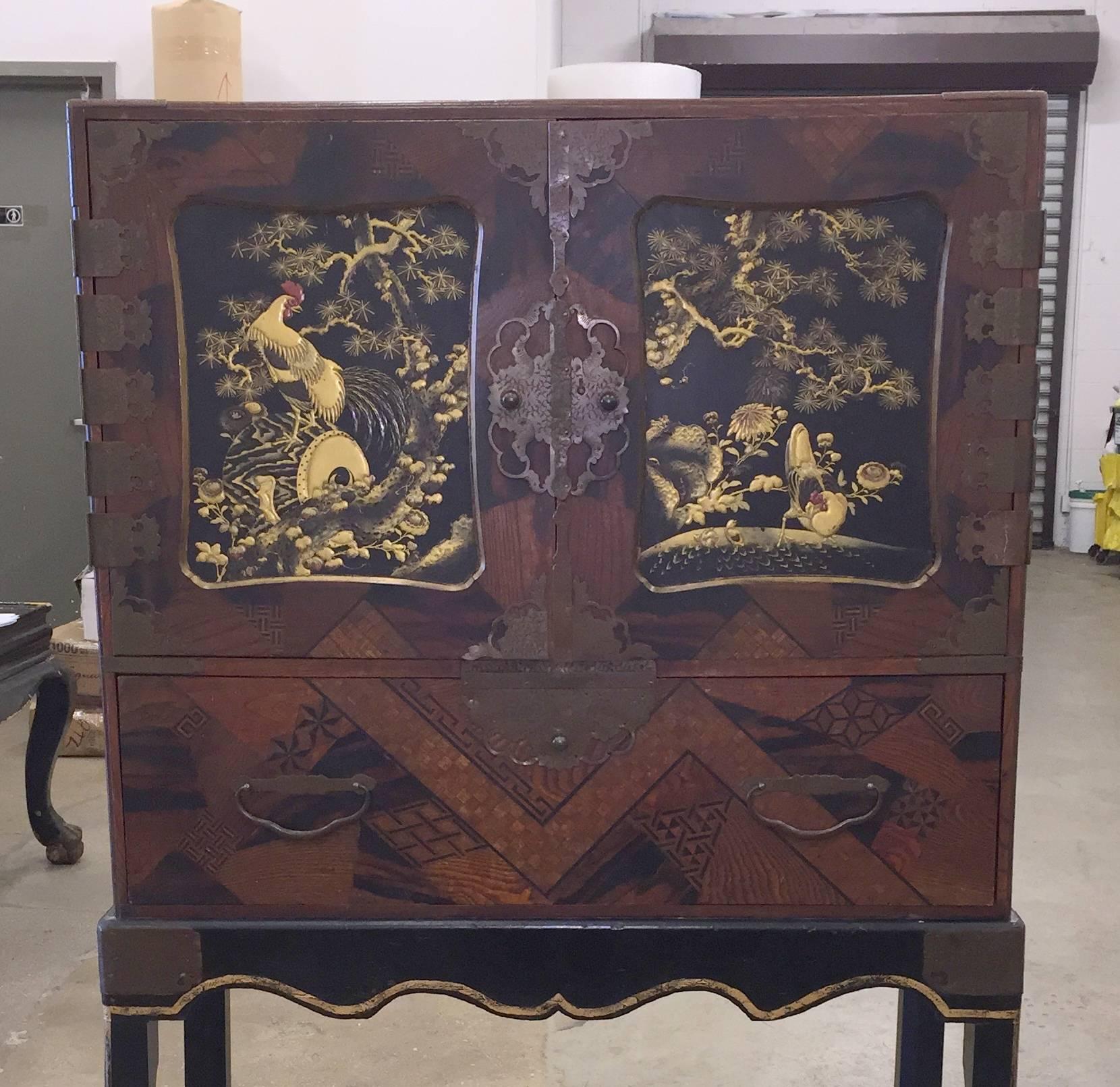 A fabulous 19th century Japanese marquetry cabinet.

Double doors with drawers inside.

Detailed makie raised lacquer design of cranes and clouds on the interiors of the doors and on the drawers.

The outside of the front has intricate inlaid