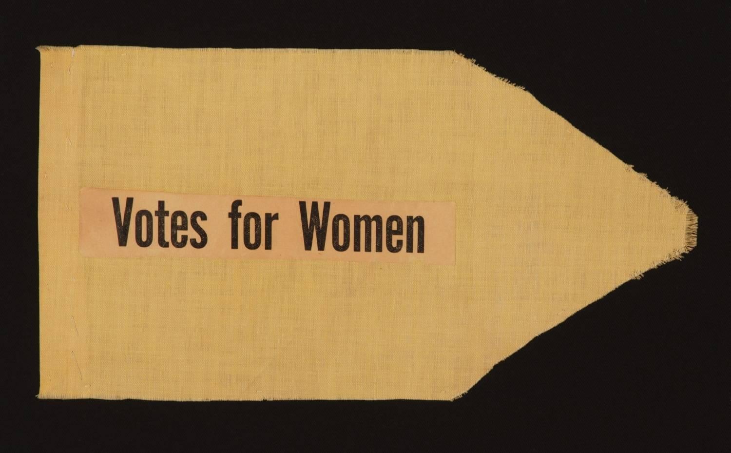 SMALL SUFFRAGETTE PENNANT WITH "VOTES FOR WOMEN" TEXT, 1910-1920

Small Suffragette pennant, made from a length of yellow cotton cloth with applied yellow paper, on which "Votes for Women" was professionally printed.  A