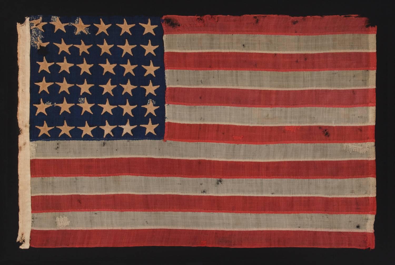 36-stars, Civil War era, made by Annin in New York City, in an unusual tiny size for the period and entirely hand-sewn, probably carried as a military camp colors or guidon, Nevada Statehood, 1864-1867.

Entirely hand-sewn American national flag