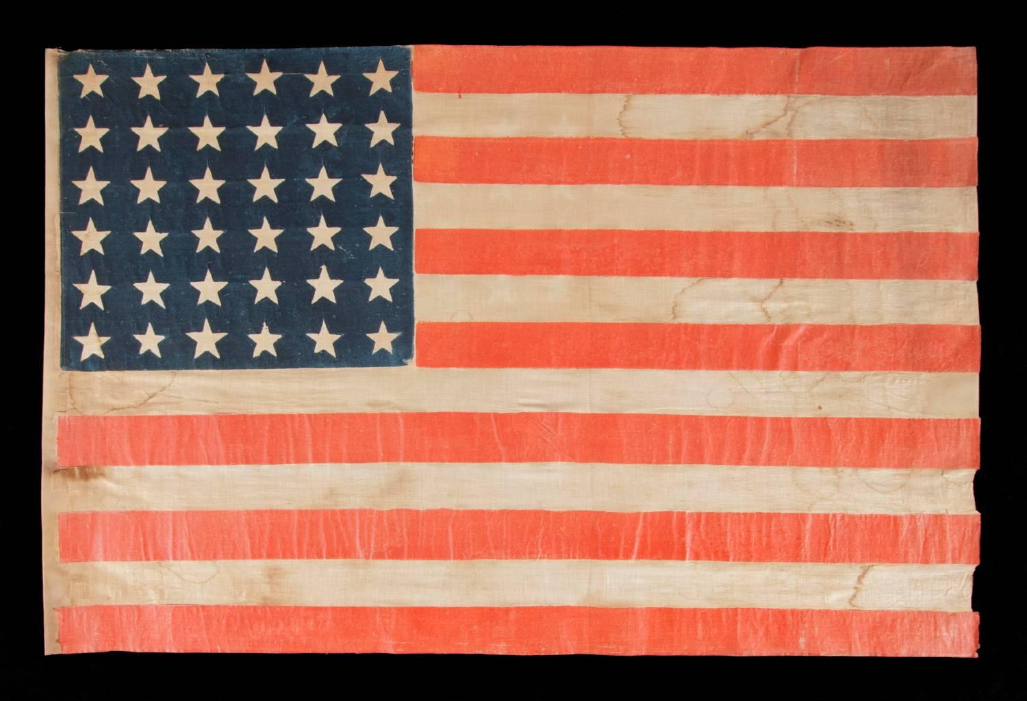 36 star antique American parade flag of the civil war era, in an especially large-scale and with bold color, 1864-1867, Nevada statehood. 

36 star American national flag of the Civil War era, printed on coarse, glazed cotton. The 36th state,