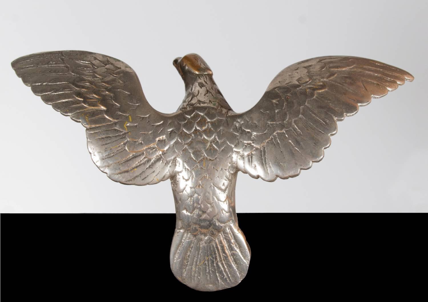 Eagle flag pole topper, made of iron and nickel-plated. The form isn't unconventional by any means, as small eagles were a popular form for flag pole finials, but the pose seen here is uncommon, with wings outstretched and slightly above the head,