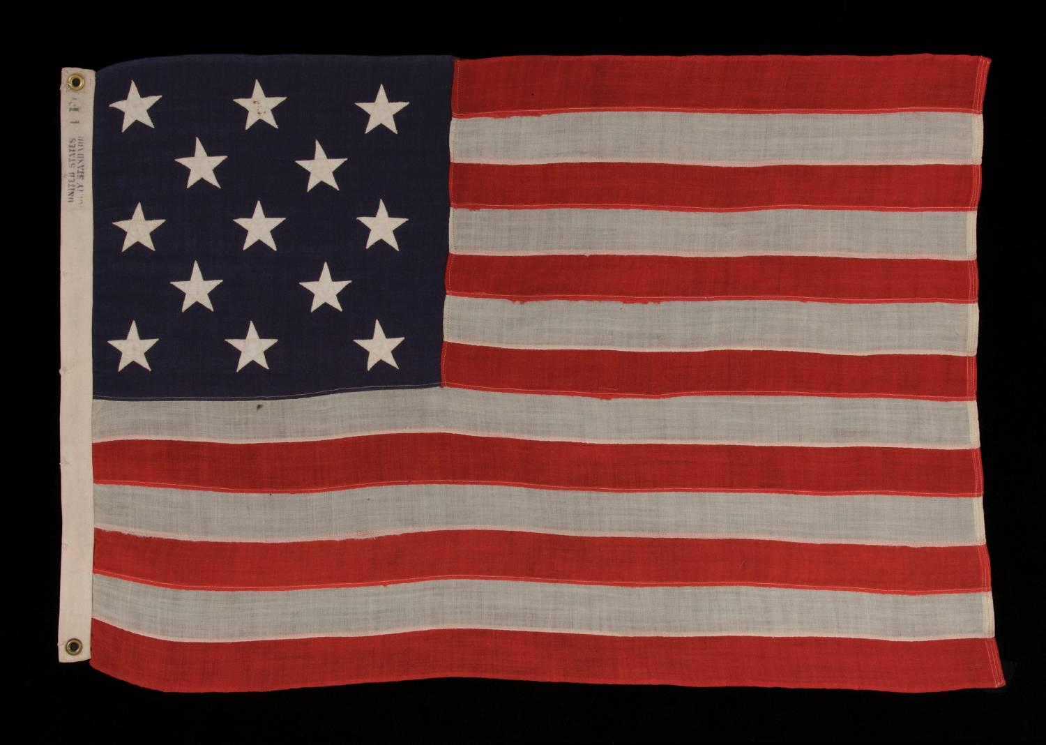 13 stars arranged in a 3-2-3-2-3 pattern on a small-scale antique american flag marked 
