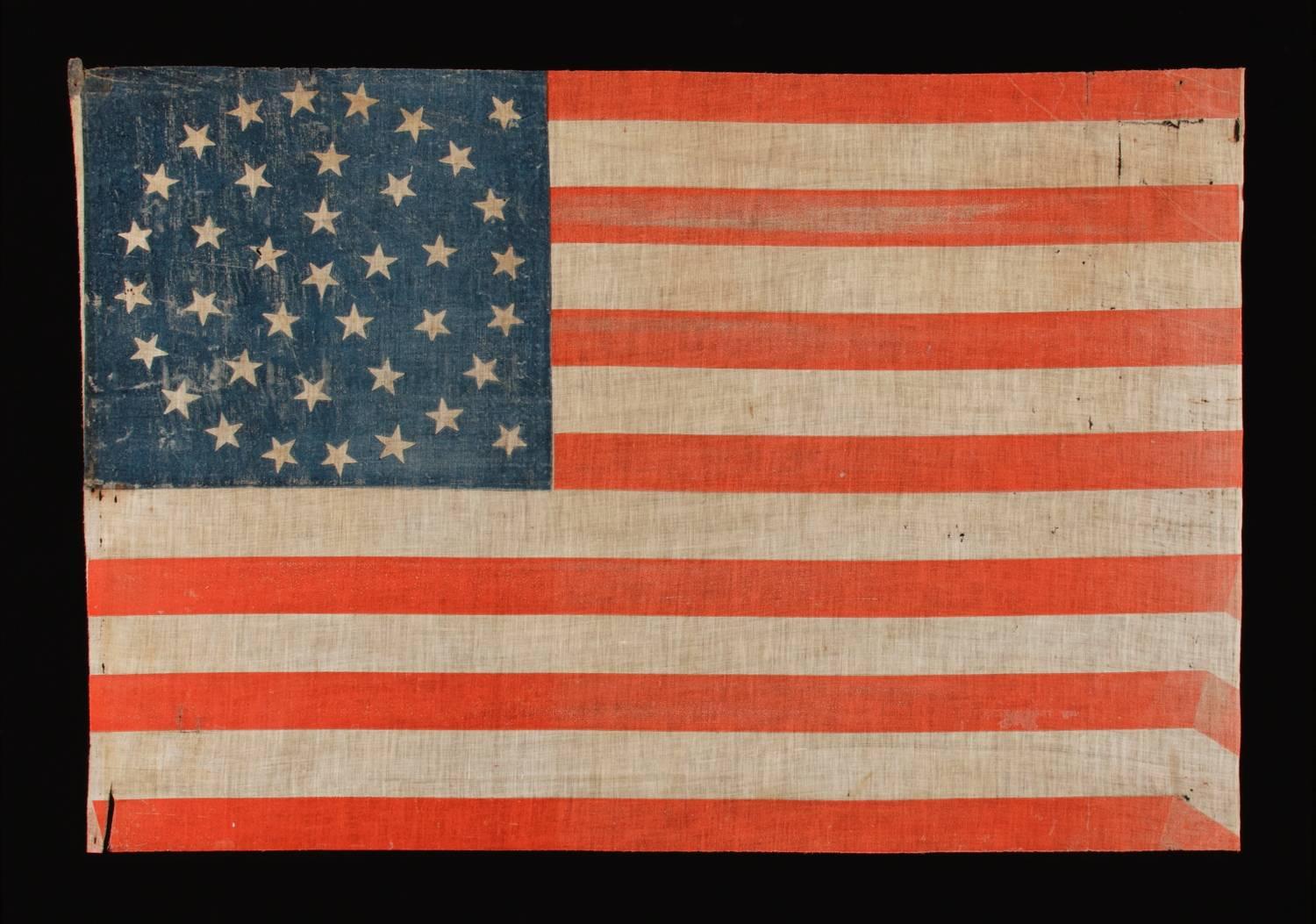 38 stars in a medallion configuration with two outliers, Colorado Statehood, 1876-1889, a large example with bold coloration 

38 star American parade flag, block-printed by hand on coarse, glazed cotton. The stars are arranged in a triple-wreath