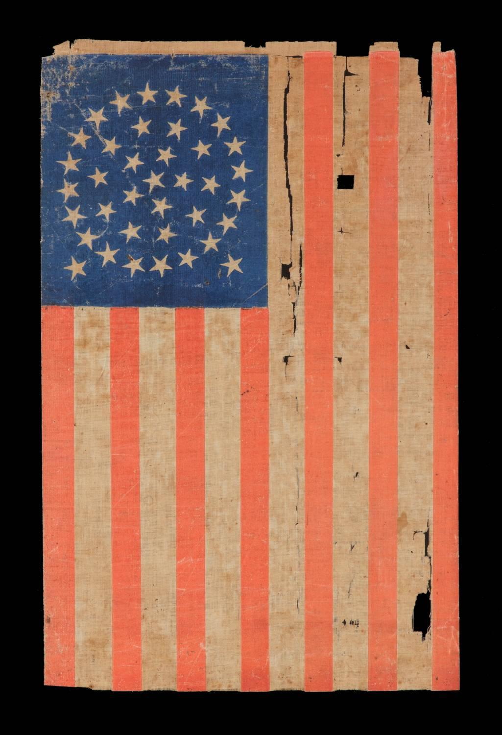 38 stars in a medallion configuration with two outliers, Colorado statehood, 1876-1889, a well-worn example with bold coloration:

38 star American parade flag, block-printed by hand on coarse, glazed cotton. The stars are arranged in a
