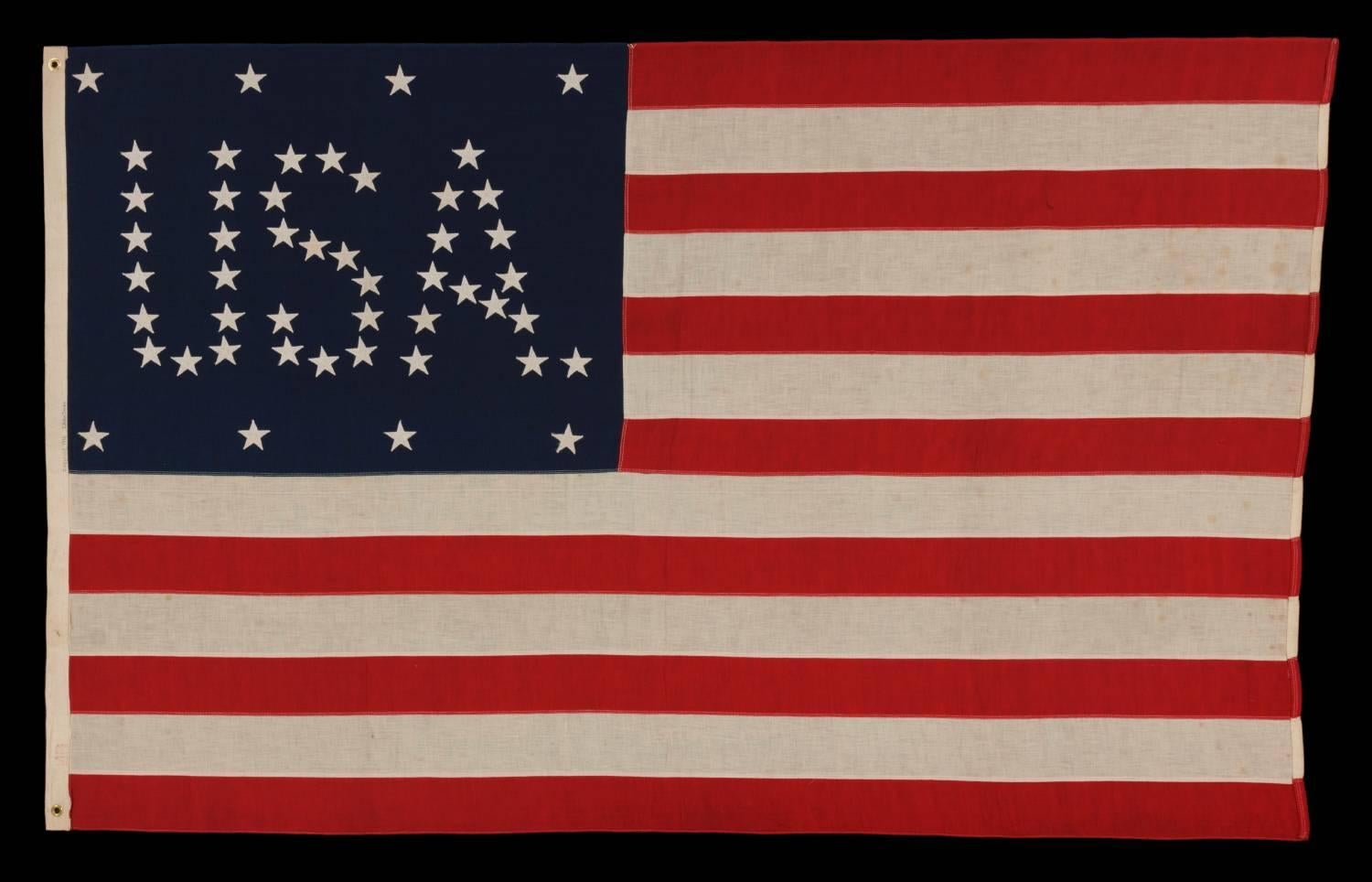 48 STARS CONFIGURED INTO THE LETTERS “U.S.A.”, COPYRIGHTED IN 1916 BY C.A. HARTMAN, ONE OF ONLY FOUR KNOWN SURVIVING EXAMPLES AND ONE OF THE MOST INTERESTING DESIGNS KNOWN TO EXIST IN EARLY FLAGS: 

48 star American national flag; one of only four