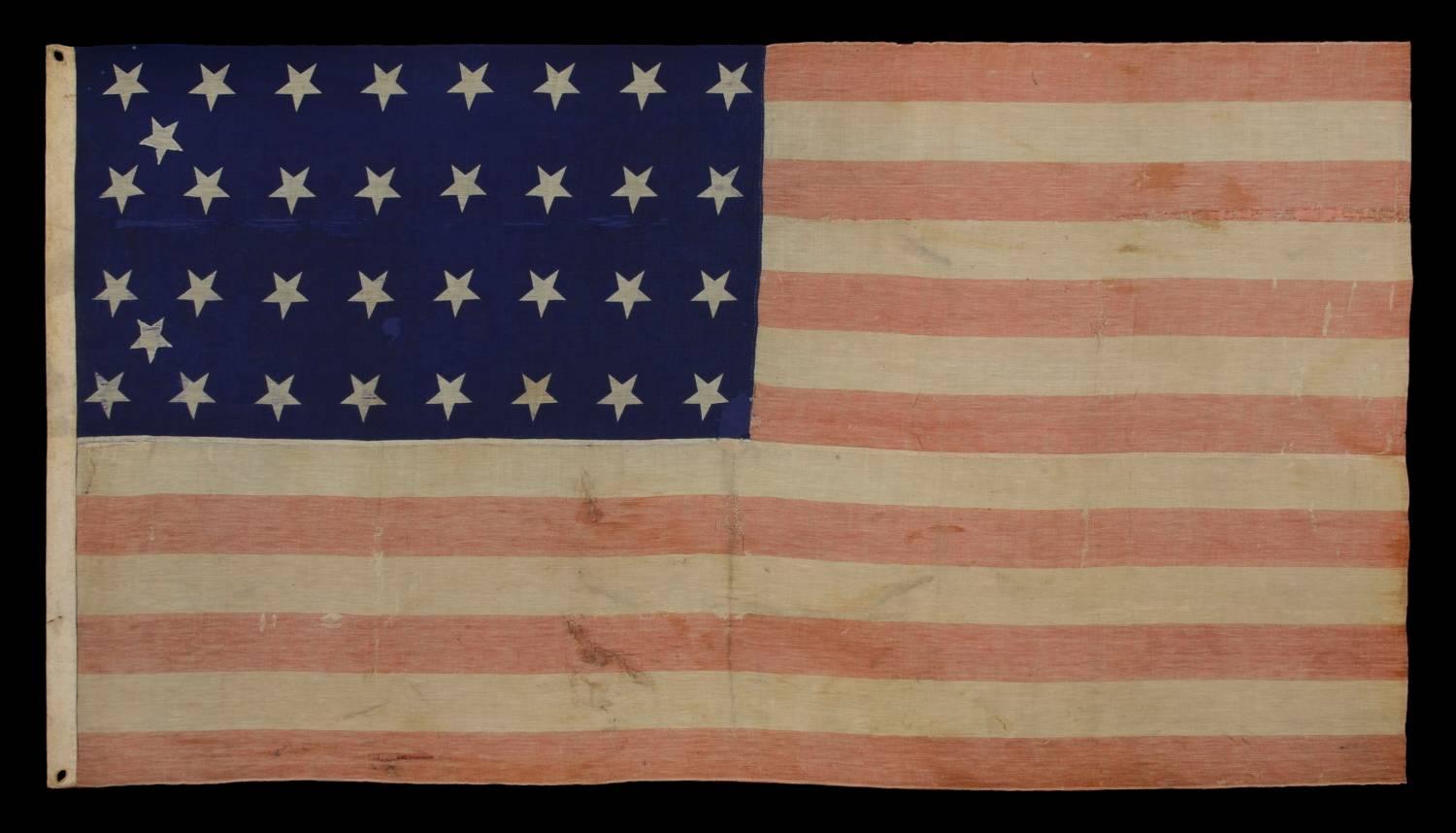 34 stars, Civil War period (1861-63), an unusual example with woven stripes and press-dyed stars, possibly made in New York by the Annin Company: 34 star flag, of the Civil War period, made of a press-dyed canton and woven stripes. This uncommon