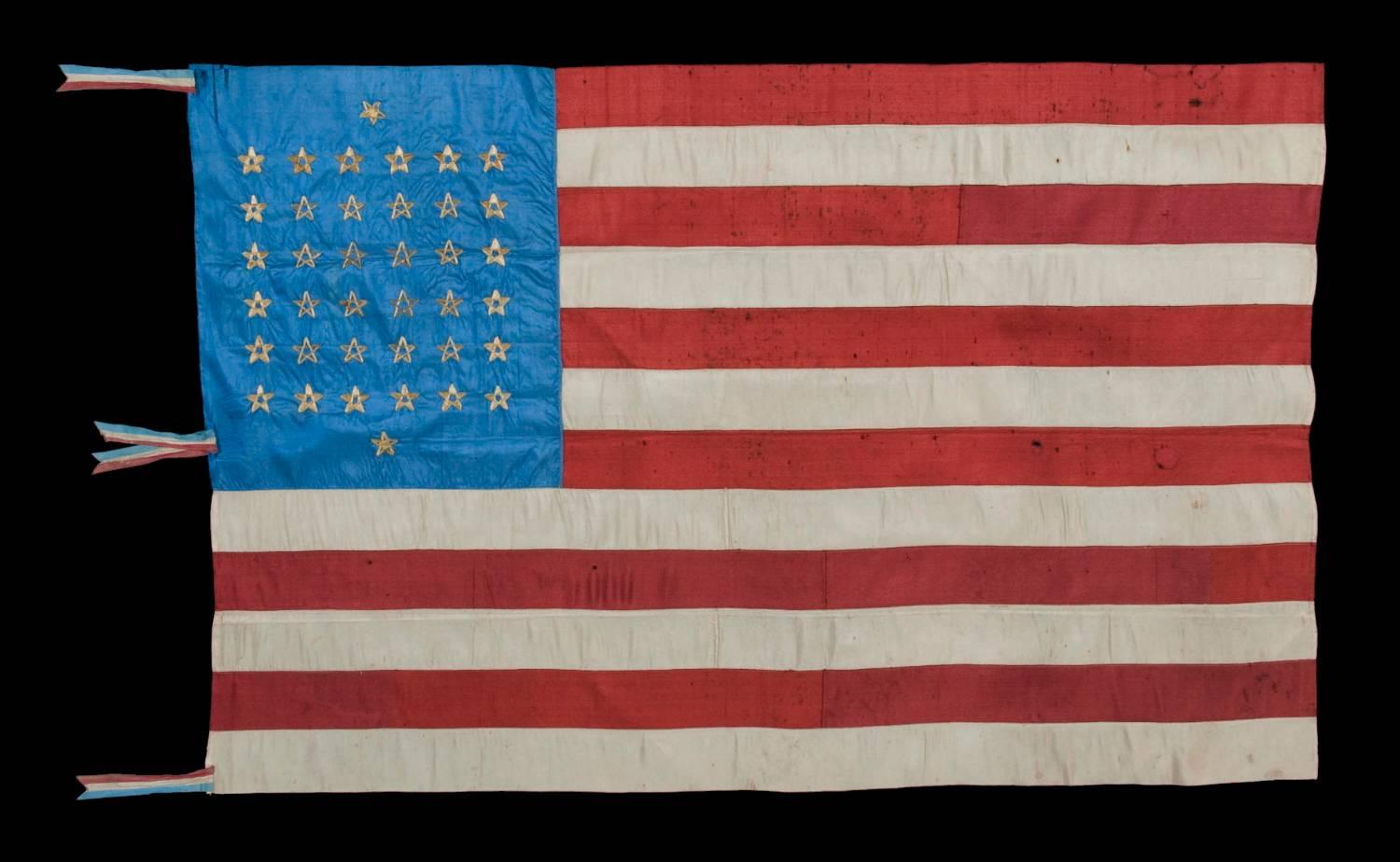 38 STAR, SILK FLAG WITH 12 STRIPES AND THREE DIFFERENT STYLES OF HAND-EMBROIDERED STARS, ARRANGED TO REFLECT THE NUMBER OF NORTHERN AND SOUTHERN SUPPORTING STATES DURING THE CIVIL WAR, AND RESULTING IN ONE OF THE MOST RARE STAR CONFIGURATIONS EXTANT