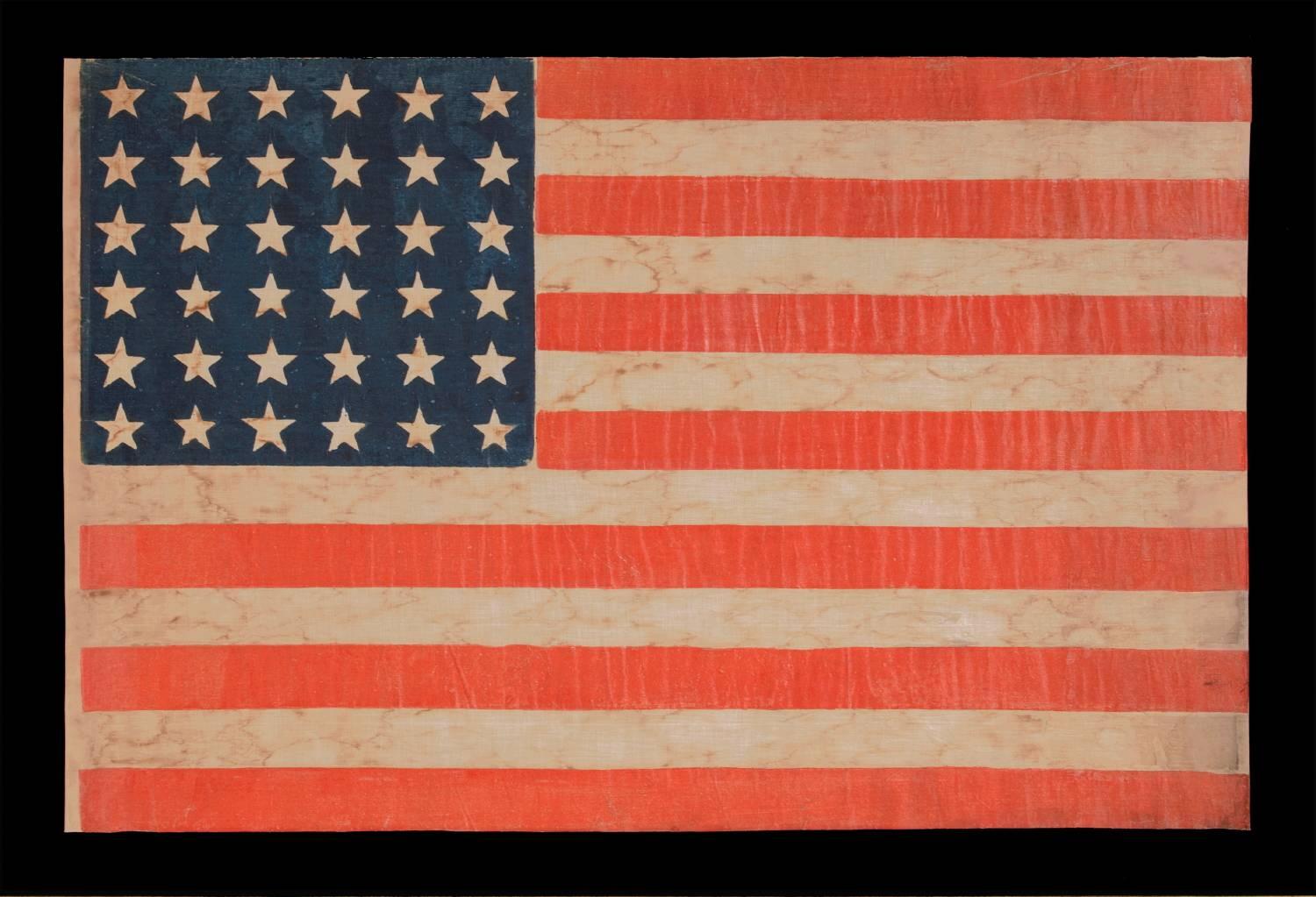 36 STAR ANTIQUE AMERICAN PARADE FLAG OF THE CIVIL WAR ERA, IN AN ESPECIALLY LARGE SCALE AND WITH BOLD COLOR, 1864-67, NEVADA STATEHOOD: 

36 star American national flag of the Civil War era, printed on coarse, glazed cotton. The 36th state, Nevada,