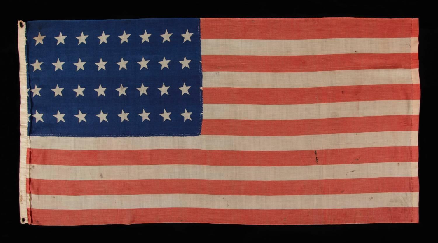 32 STAR ANTIQUE AMERICAN FLAG, REPRESENTING MINNESOTA STATEHOOD, 1858-59, IN A STYLE KNOWN TO HAVE SEEN MILITARY SERVICE DURING THE FORTHCOMING CIVIL WAR (1861-65) AND BEARING THE SIGNATURE OF A SOLDIER WHO FOUGHT WITH THE 15TH MICHIGAN INFANTRY,