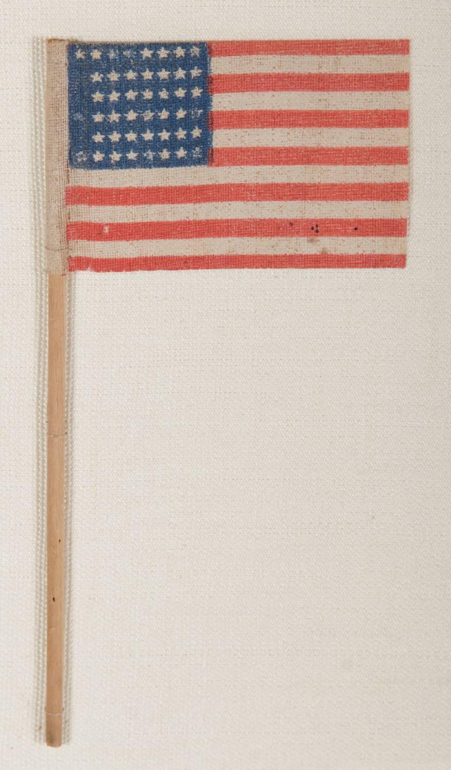 45 Stars in a "NOTCHED" Design, leaving space open for the future addition of three more western territories, Utah statehood, 1896-1908:

45 star American parade flag, printed on coarse, glazed cotton and affixed to its original wooden