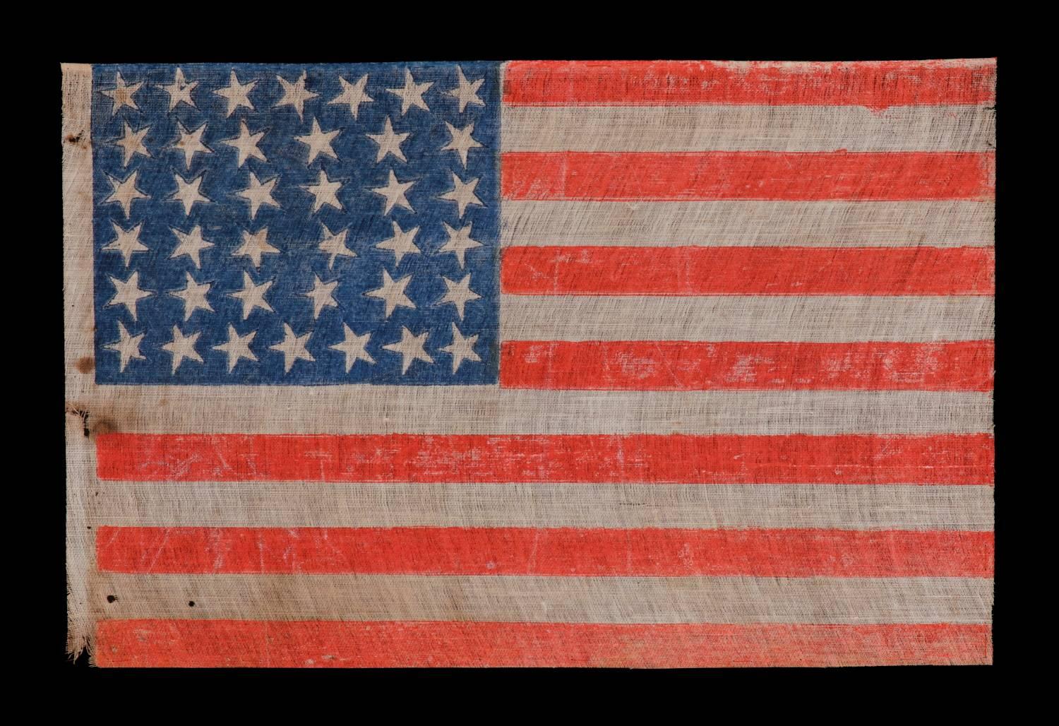 38 ESPECIALLY FOLKY STARS AND ON AN ANTIQUE AMERICAN PARADE FLAG WITH STRONG COLORATION, ON COTTON AND FLAX BLENDED FABRIC WITH A CRUDE WEAVE, COLORADO STATEHOOD, 1876-1889: 

38 star American national parade flag, printed on coarse, glazed cotton.