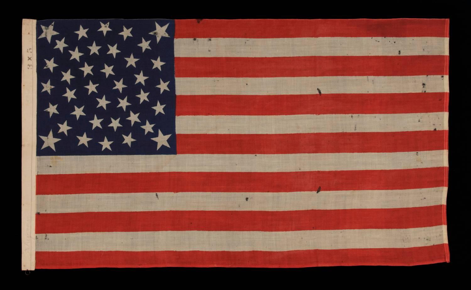 38 STARS ON AN EXTRAORDINARY ANTIQUE FLAG MADE FOR THE 1876 CENTENNIAL EXPOSITION, LIKELY BY THE HORSTMANN COMPANY IN PHILADELPHIA, WITH AN EXTREMELY RARE FORM OF THE MEDALLION CONFIGURATION THAT BEARS AN ELLIPSE OF SIX STARS IN THE CENTER AND A