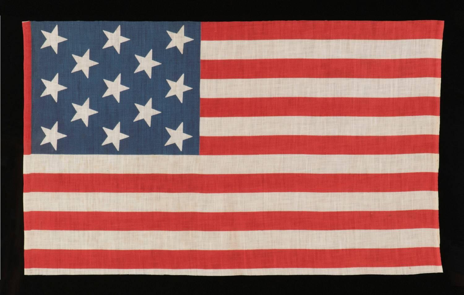13 STAR PARADE FLAG IN A 3-2-3-2-3 PATTERN, MADE CA 1876-1898, UNUSUALLY LARGE AND WITH AN UNUSUAL STAR PATTERN AMONG ITS COUNTERPARTS OF THE 19TH CENTURY: 

13 star American national parade flag, printed on cotton, made sometime in the period