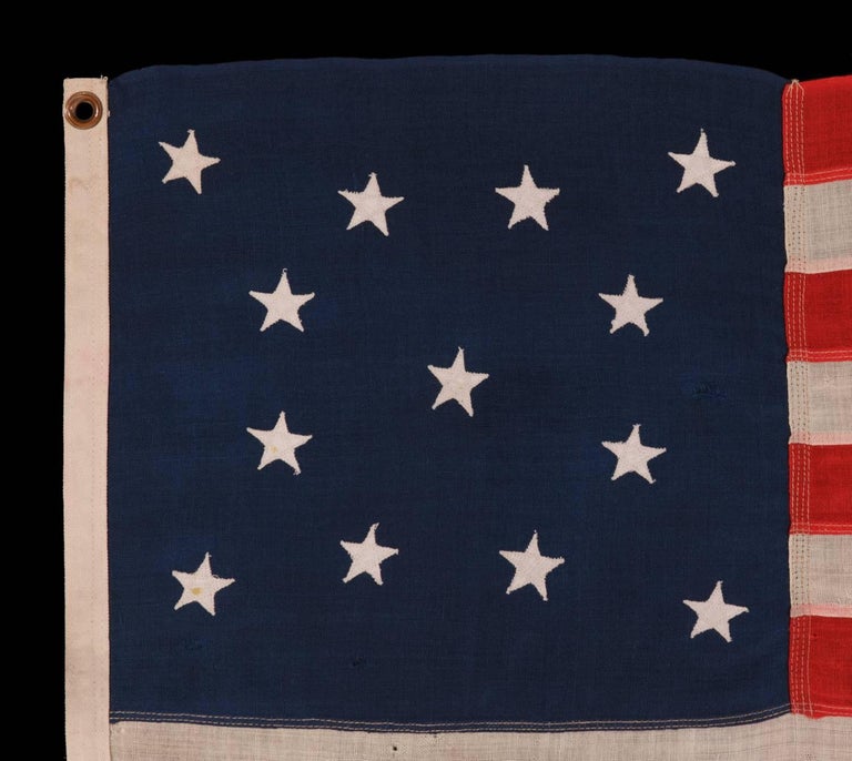 13 STARS IN A MEDALLION CONFIGURATION ON A SMALL-SCALE ANTIQUE AMERICAN FLAG OF THE 1890-1900 ERA:

 13 star flag of the type made from roughly the last decade of the 19th century through the first quarter of the 20th. The stars are arranged in a