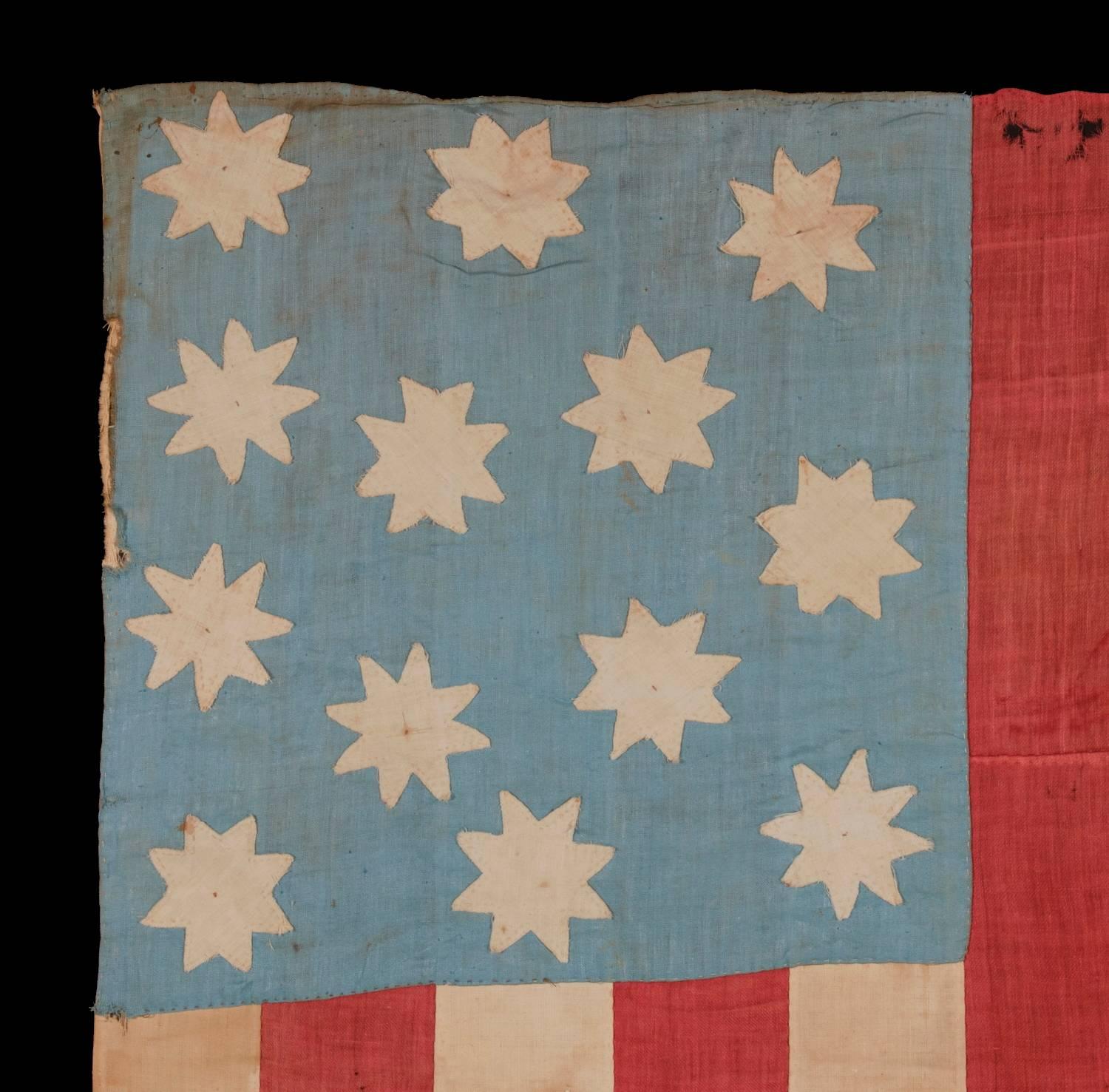 Extraordinary, hand-sewn, 13 star American national flag with 8-pointed stars on a glazed cotton, cornflower blue, 12 stripes and its canton resting on the war stripe, found in upstate, New York, pre-civil war, circa 1830-1850.

Homemade and