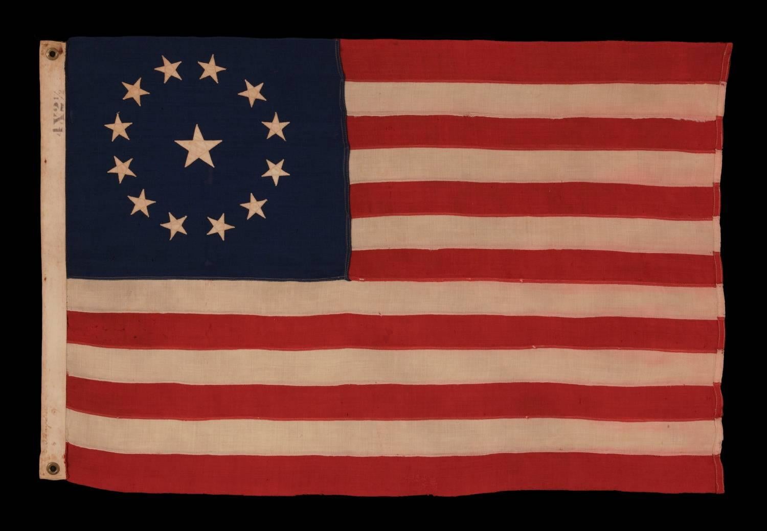 13 STARS IN A CIRCULAR VERSION OF THE 3RD MARYLAND PATTERN, ON AN ESPECIALLY ATTRACTIVE, SMALL SCALE, ANTIQUE AMERICAN FLAG, MADE IN THE 1890-1910 ERA:

 13 star flags have been flown throughout our nation’s history for a variety of purposes. They