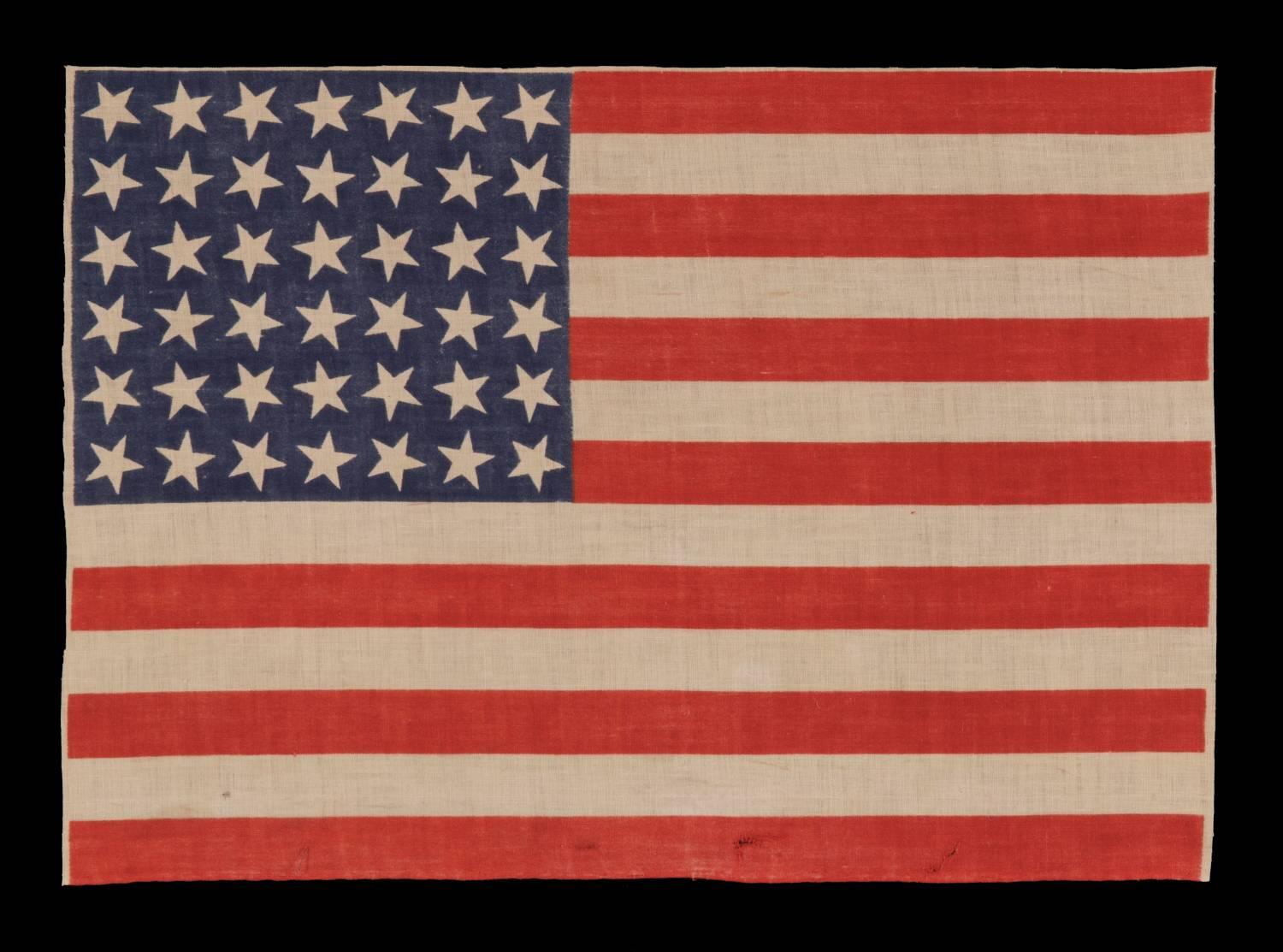 42 stars, 1889-1890, an unofficial star count, Washington statehood, scattered star positioning

42 star parade flag, printed on cotton muslin. The stars are arranged in a rectilinear fashion, but vary in position on their vertical axis. This adds