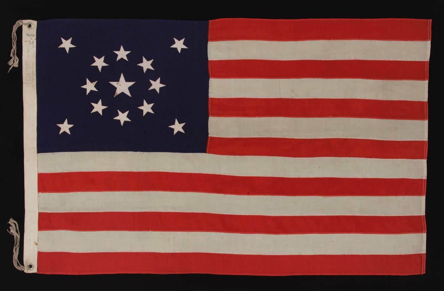 13 stars arranged in a medallion pattern on a small-scale flag of the 1895-1926 era:

 13 star flag of the type made from roughly the last decade of the 19th century through the first quarter of the 20th century. The stars are arranged in a