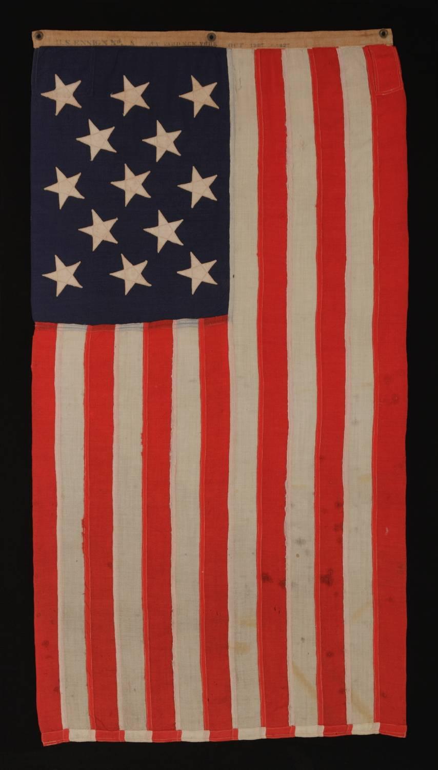 13 stars, a us navy small boat ensign made at the Brooklyn Navy Yard, New York, dated 1907:

13 star American national flag of the type used by the U.S. Navy on small boats around the turn-of-the-century. The reverse side of the coarse linen