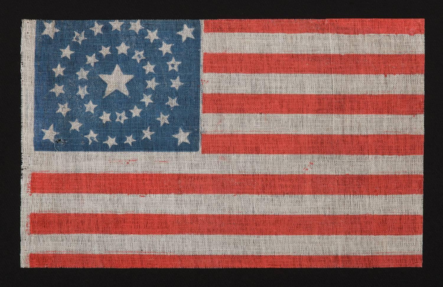 37 STARS IN A MEDALLION CONFIGURATION ONN AN ANTIQUE AMERICAN PARADE FLAG, 1867-1876, NEBRASKA STATEHOOD:

 37-star American national parade flag, printed on coarse, glazed cotton. The stars are arranged in a beautiful medallion that consists of