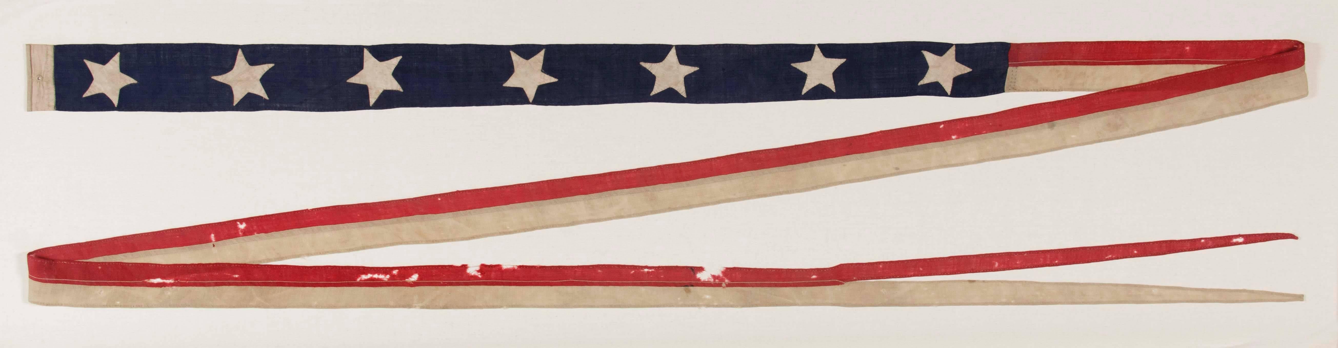 U.S. Navy Commissioning Pennant with 7 stars, possibly made aboard ship, circa 1864-1865.

 Commissioning pennants are the distinguishing mark of a commissioned U.S. Navy ship. These have a narrow blue canton, followed by one red over one white