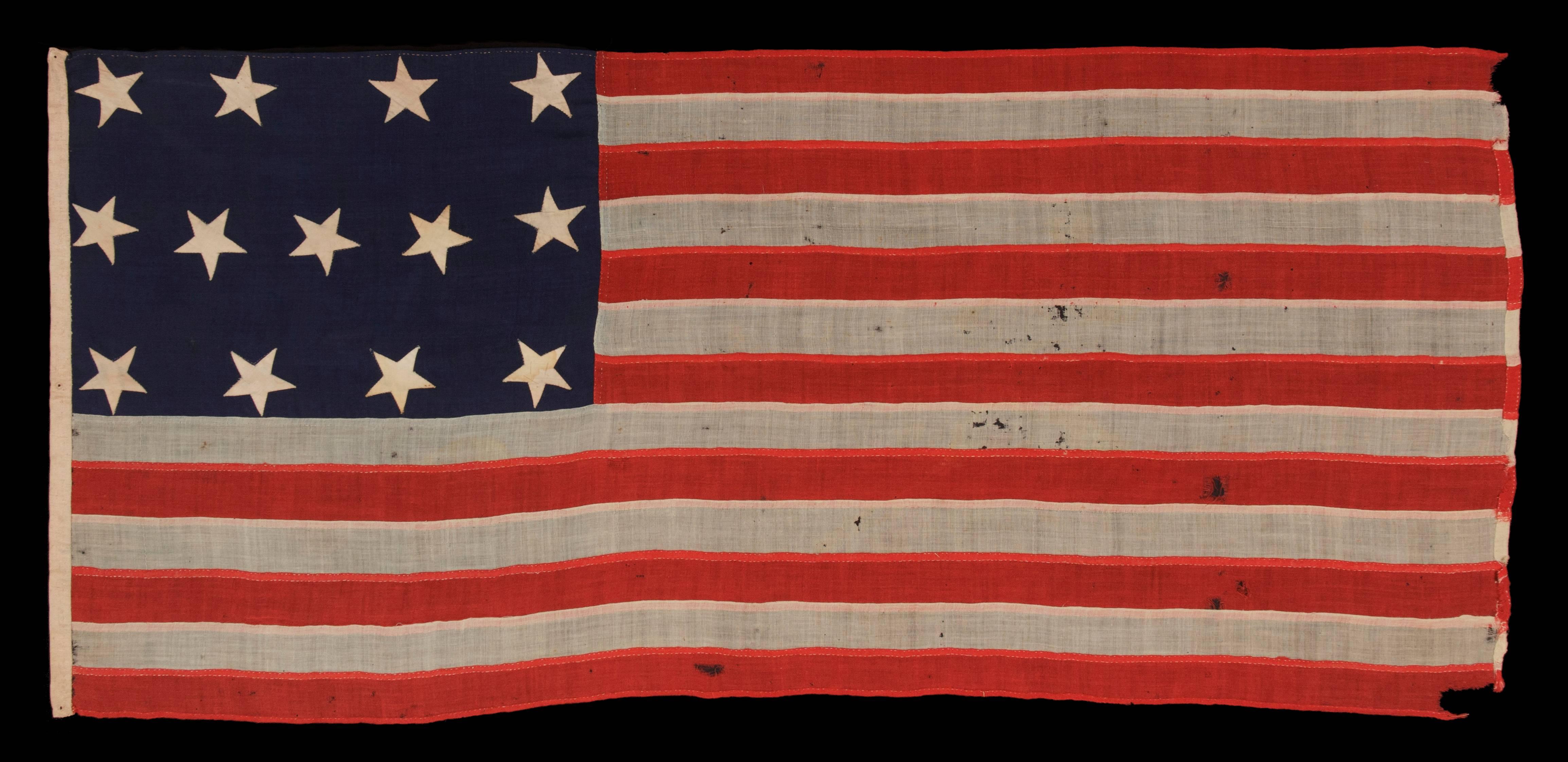 ENTIRELY HAND-SEWN, U.S. NAVY SMALL BOAT ENSIGN OF THE CIVIL WAR PERIOD, WITH 13 STARS IN A 4-5-4 CONFIGURATION, IN THE SMALLEST REGULATION SIZE RECORDED BY THE NAVY DURING THIS GENERAL ERA: 

U.S. Navy small boat ensign with 13 stars arranged in a