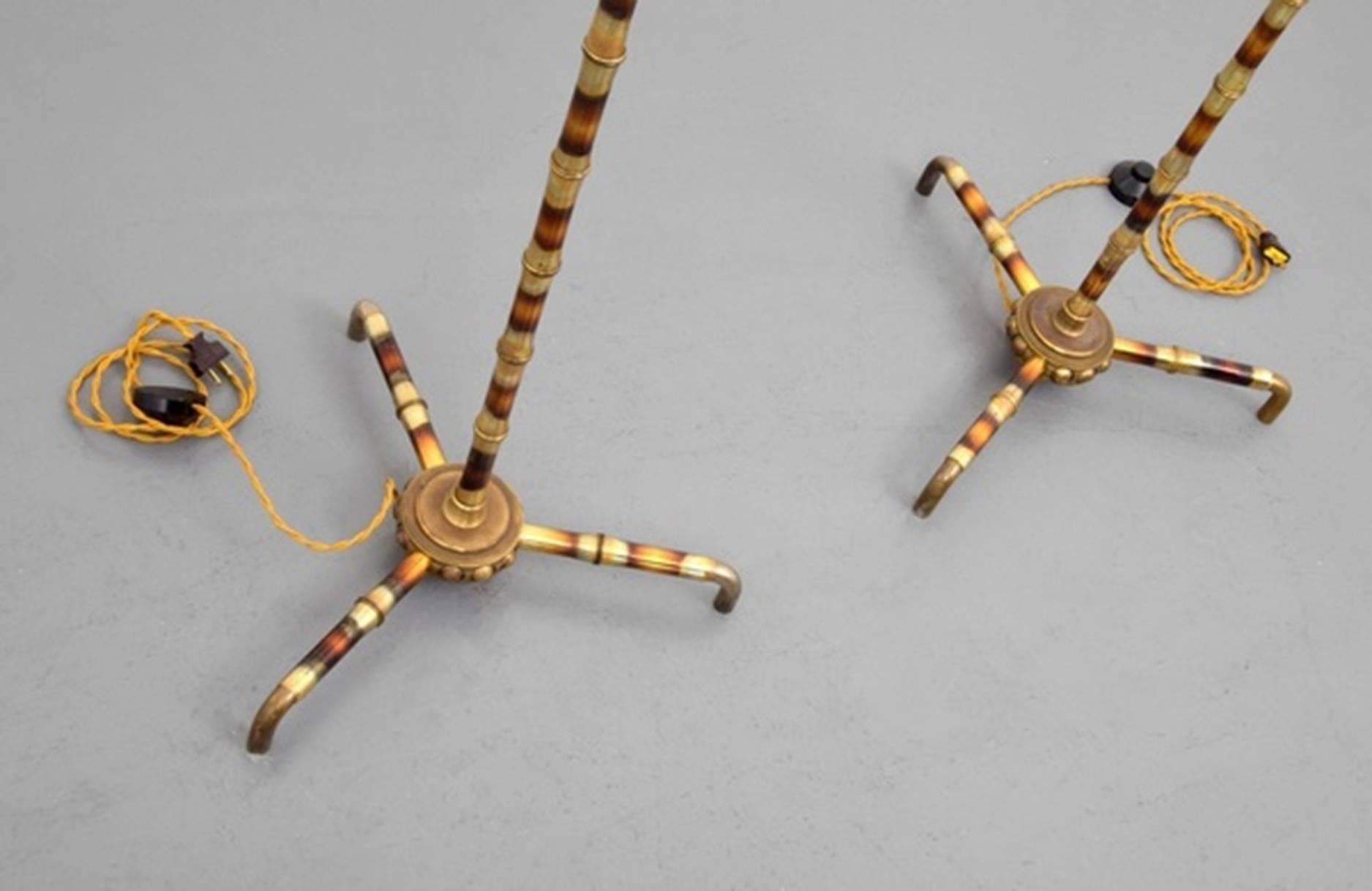 A rare pair of French floor lamps manufactured in the 1950s attributed to Maison Baguès. The lamps have a unique brass finish resembling faux bamboo, and an interesting leg design.

