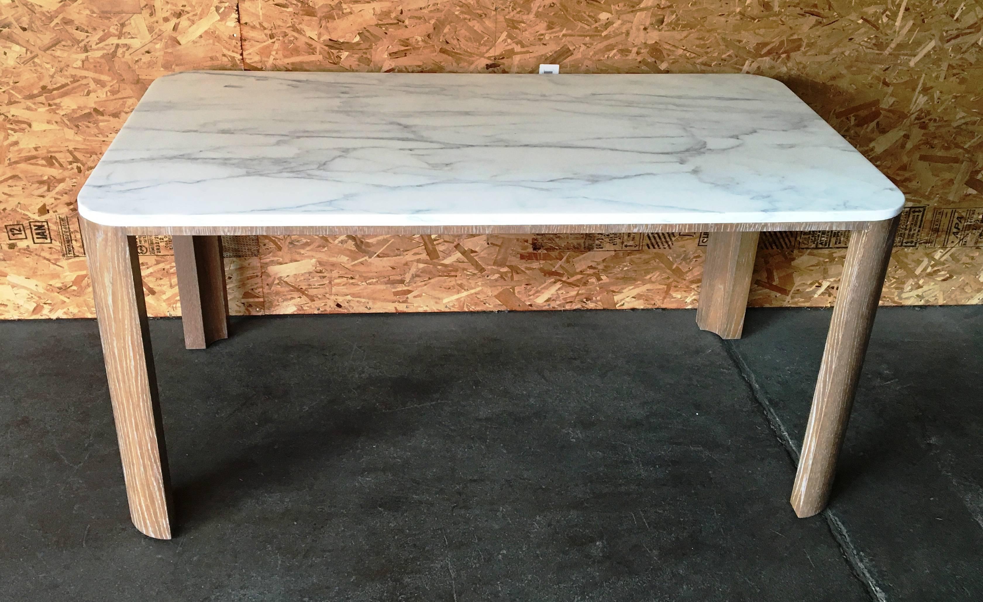 A sleek table made with aged white oak for the base, and white marble for the top. 