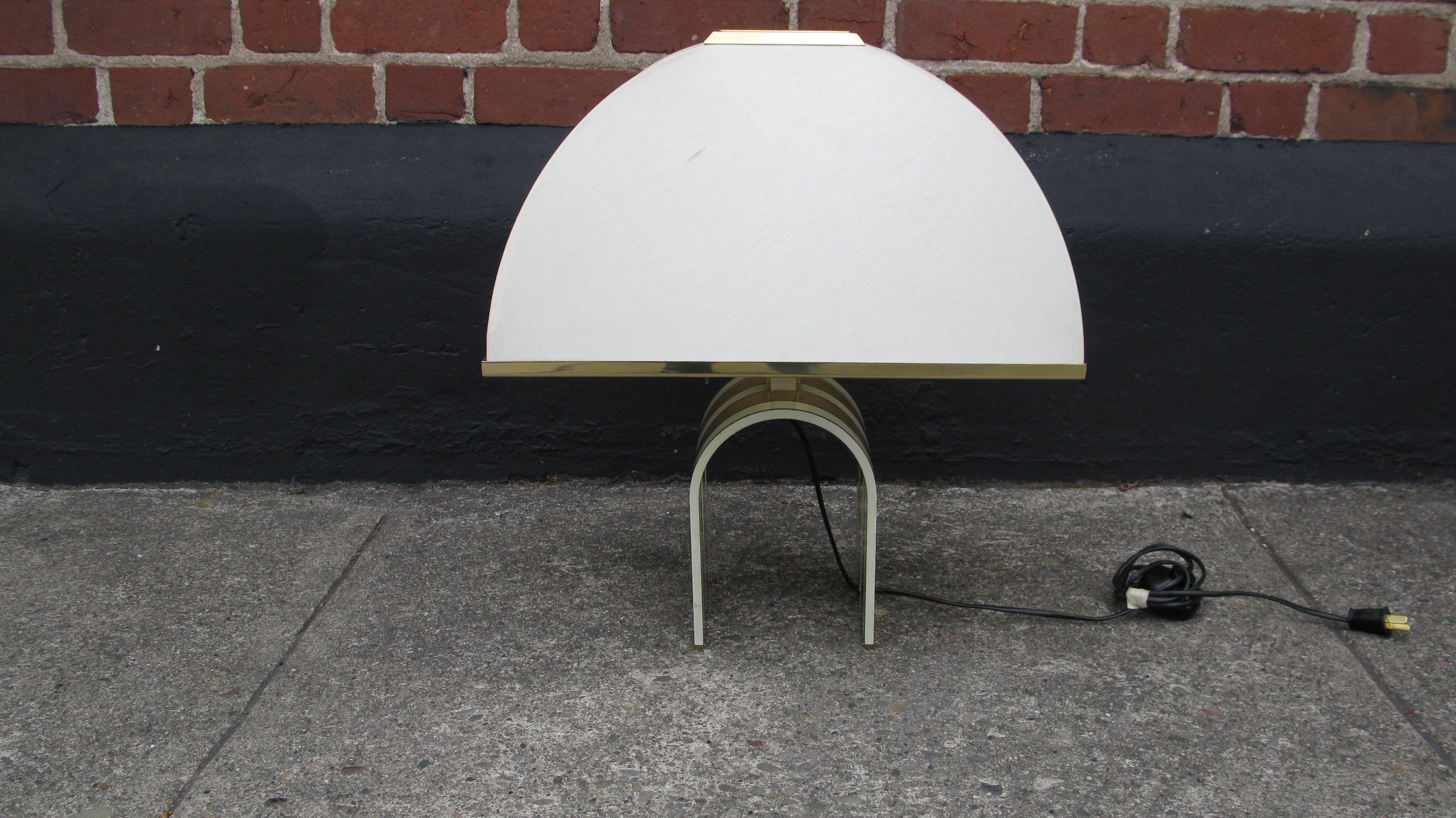 Whimsical table lamp in brass. White and brass arc design are unique and modern. Curved shade adds to the curved design. Vintage shade that has some minor wear.

Measures: 6.25