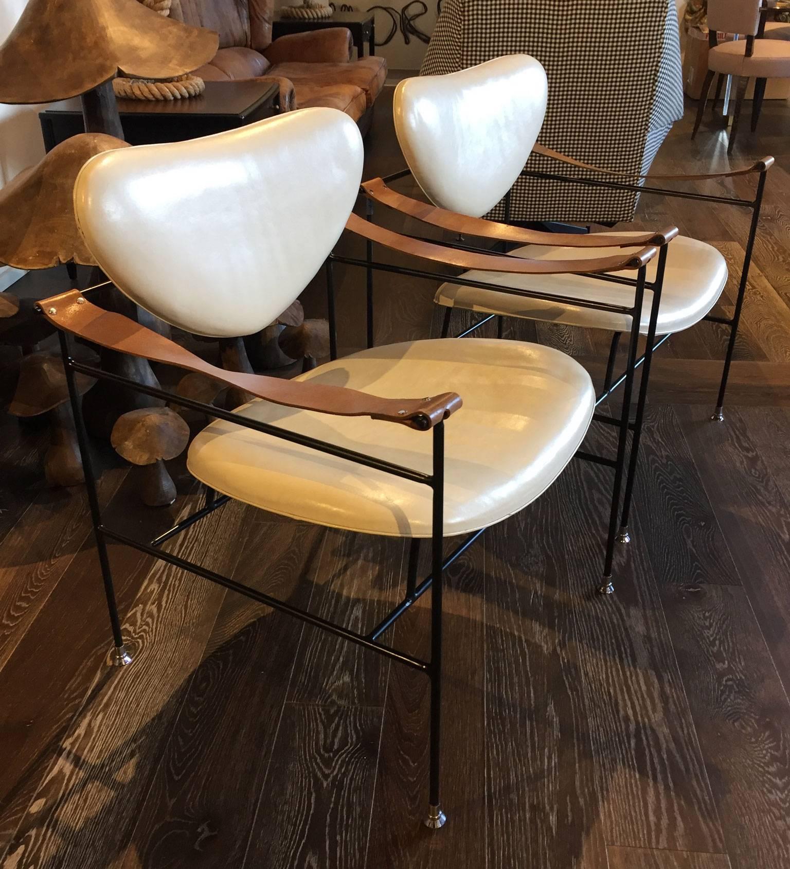 Pair of metal side chairs. Heart shaped backs and seats in a cream leather with a grey hue. Floating arms in a natural brown leather. Iron legs and frame in superb condition.