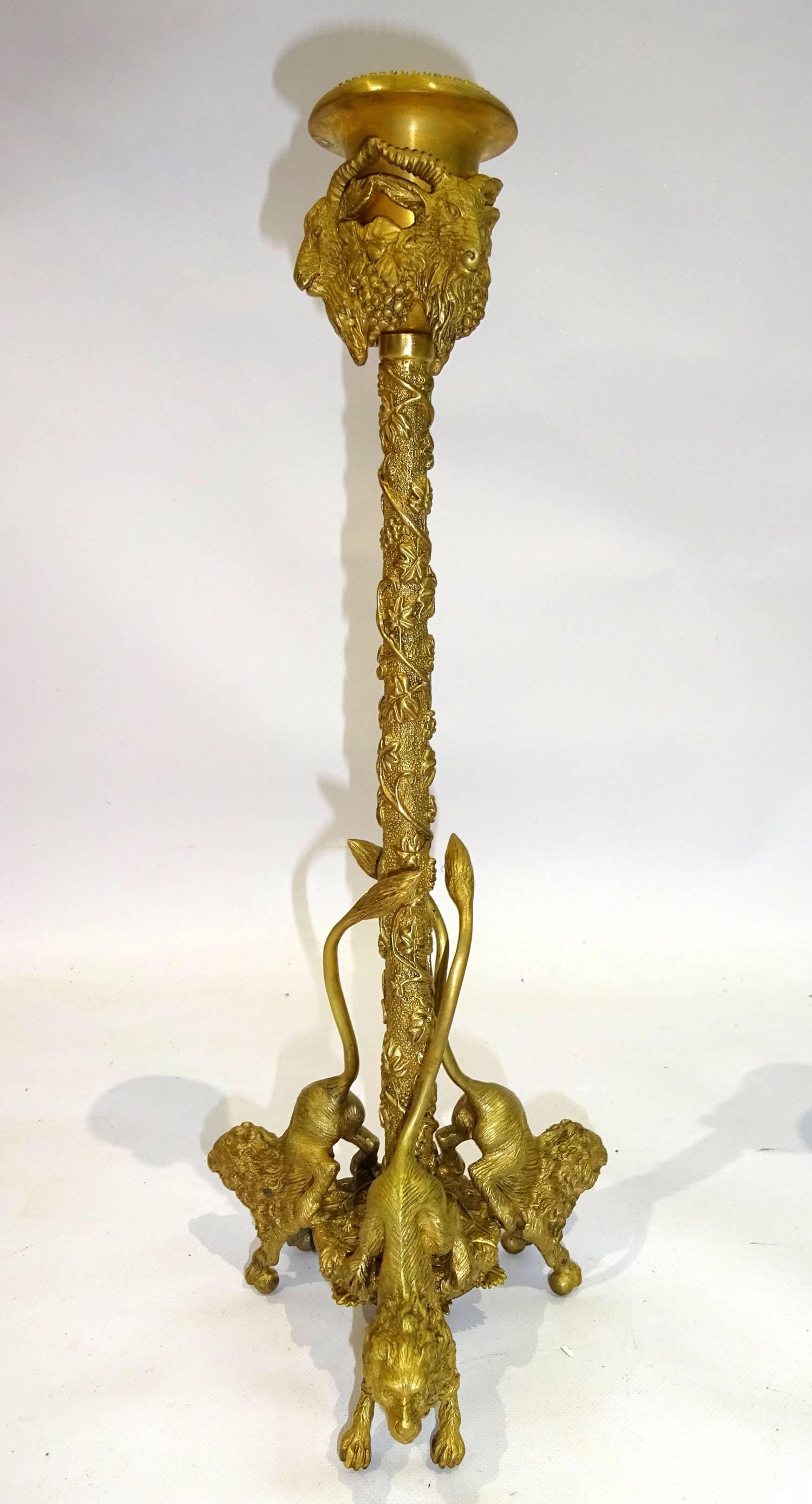 Pair of 20th century French candlesticks with beaded trim to bobeche, rams' head mounts to cup, standard with pebbled ground and vine motif in high relief, terminating on figural lion feet.