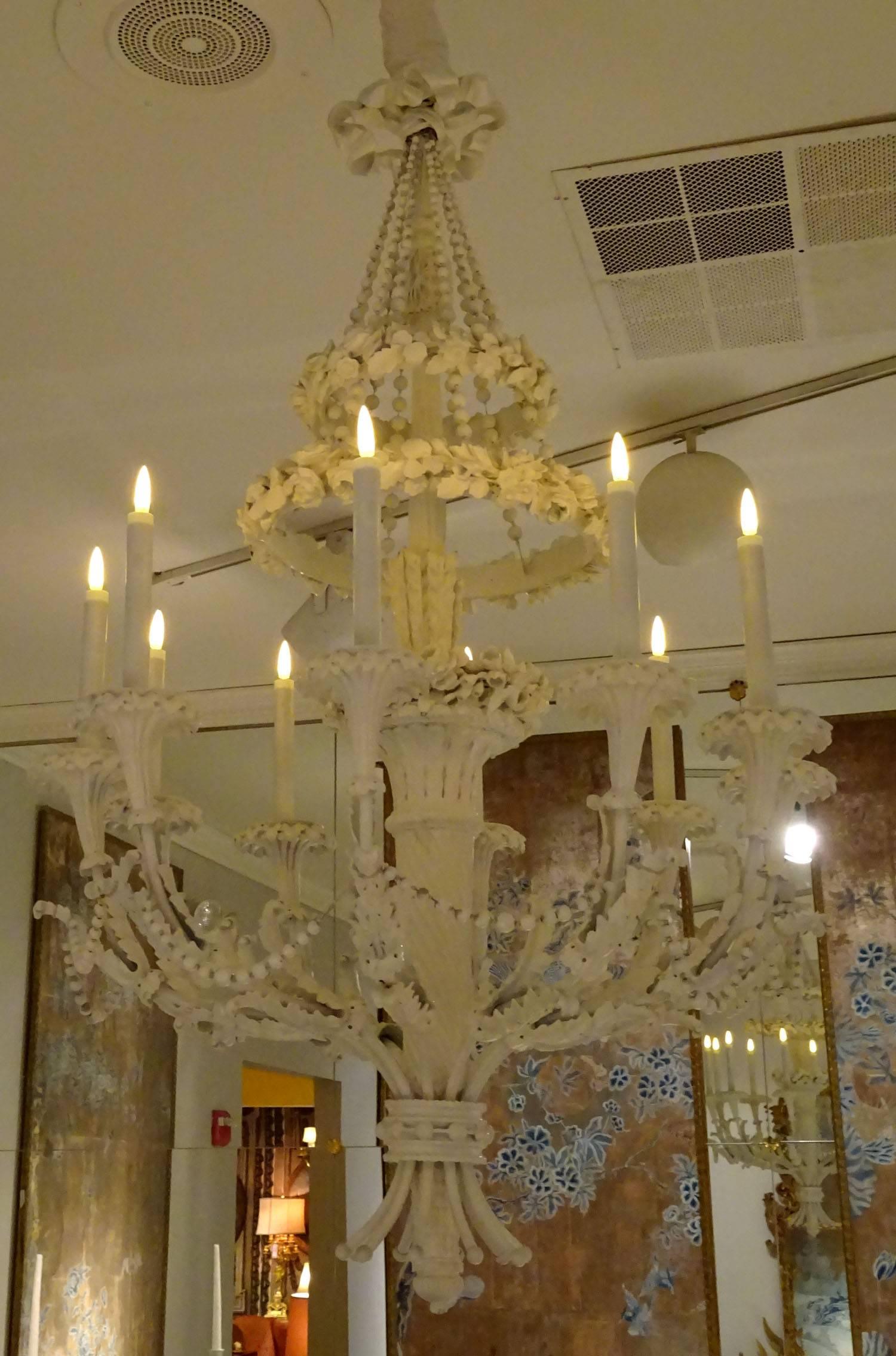 20th century continental chandelier of ornately carved wood in a painted white finish.
