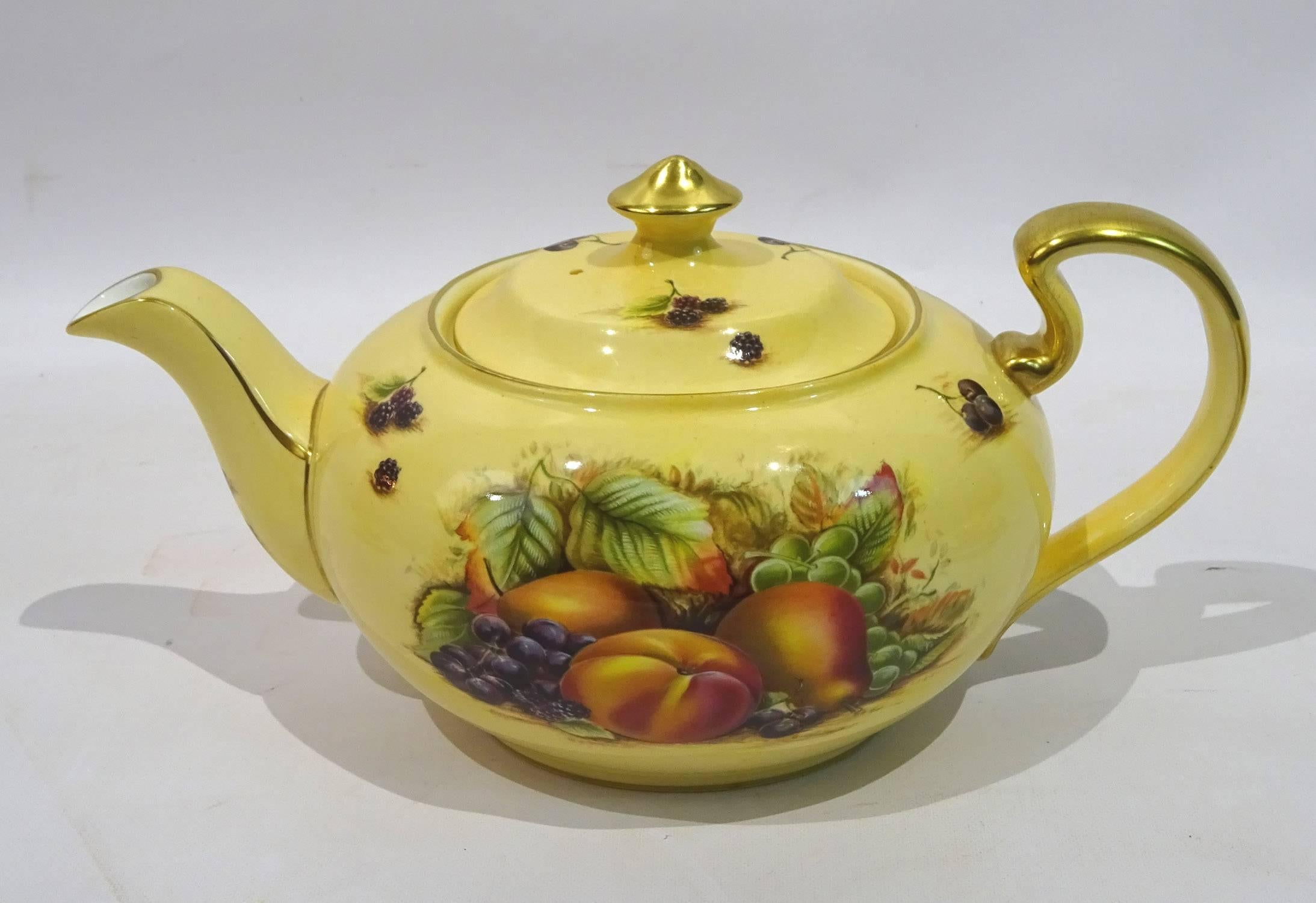 Nine-piece set of Orchard Gold China by John Aynsley, consisting of a tea and dessert service for two with a lidded tea pot, lidded sugar bowl, creamer, two cups and saucers and two dessert plates.

Teapot: 5