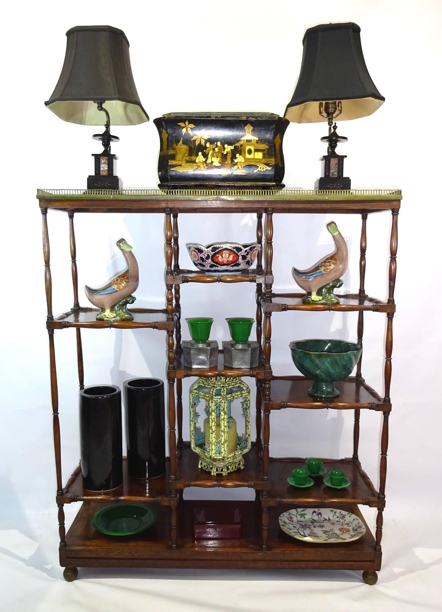 Mid-19th century English mahogany etagere with brass gallery, shaped edges and uprights and raised on ball feet. The mahogany finish has an excellent patina.