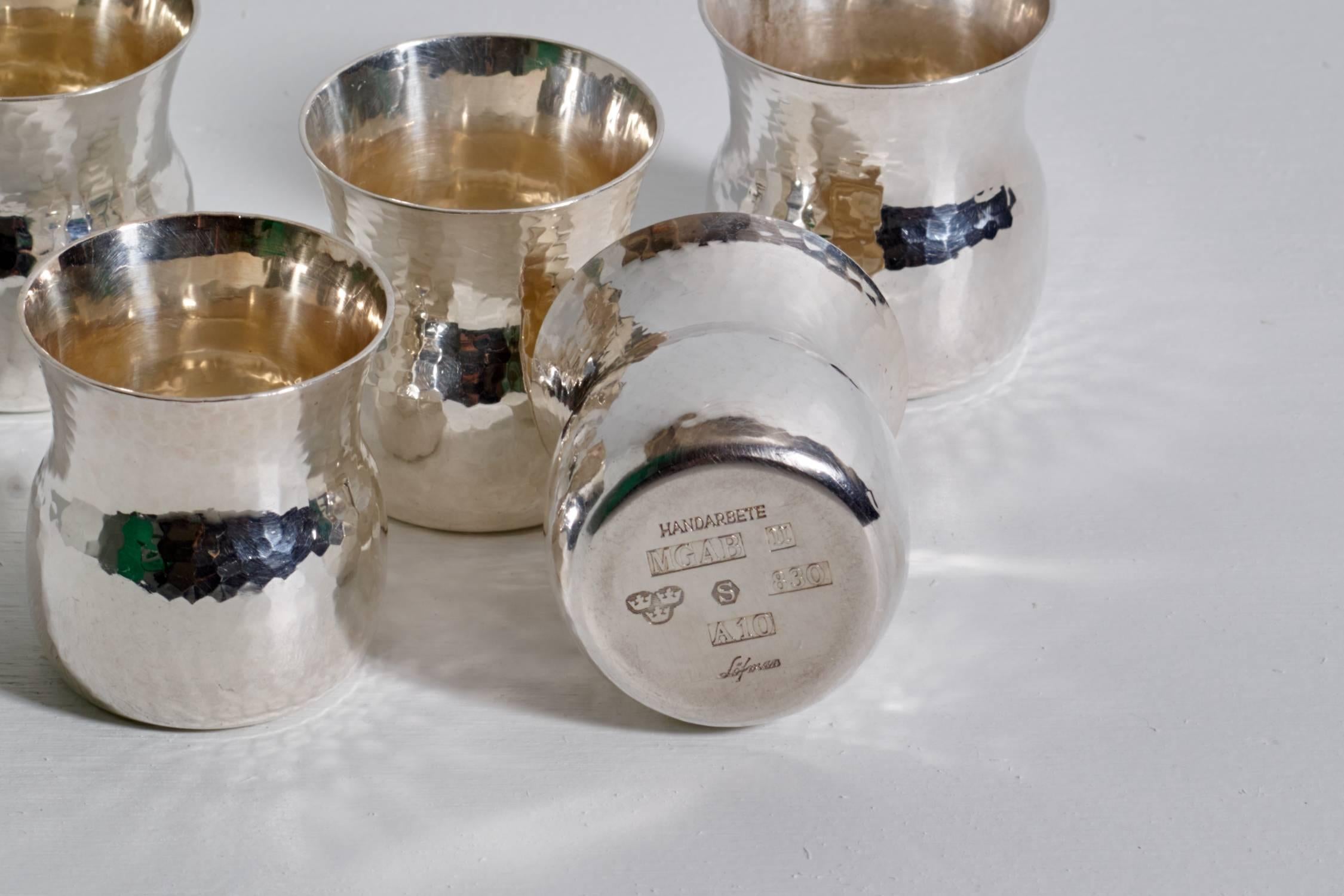Eric Löfman, set of hand-hammered sterling silver cups with accompanying bowl. Originally designed for service of punch or similar cocktail service. 

Uppsala, Sweden, circa 1974-1975.

Sterling silver, all pieces handmade with hand-hammered
