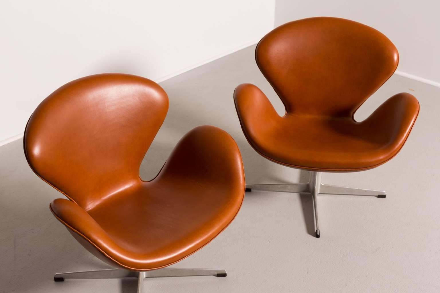 Arne Jacobsen swan chairs (pair) with early flute base.

Fritz Hansen,
Denmark, circa 1957.

Measure: 30 W x 26 D x 31 H.
Cognac leather, cast aluminum, plastic.