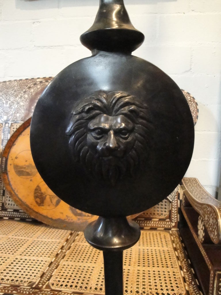 Custom bronze floor lamps with lion's head detail.