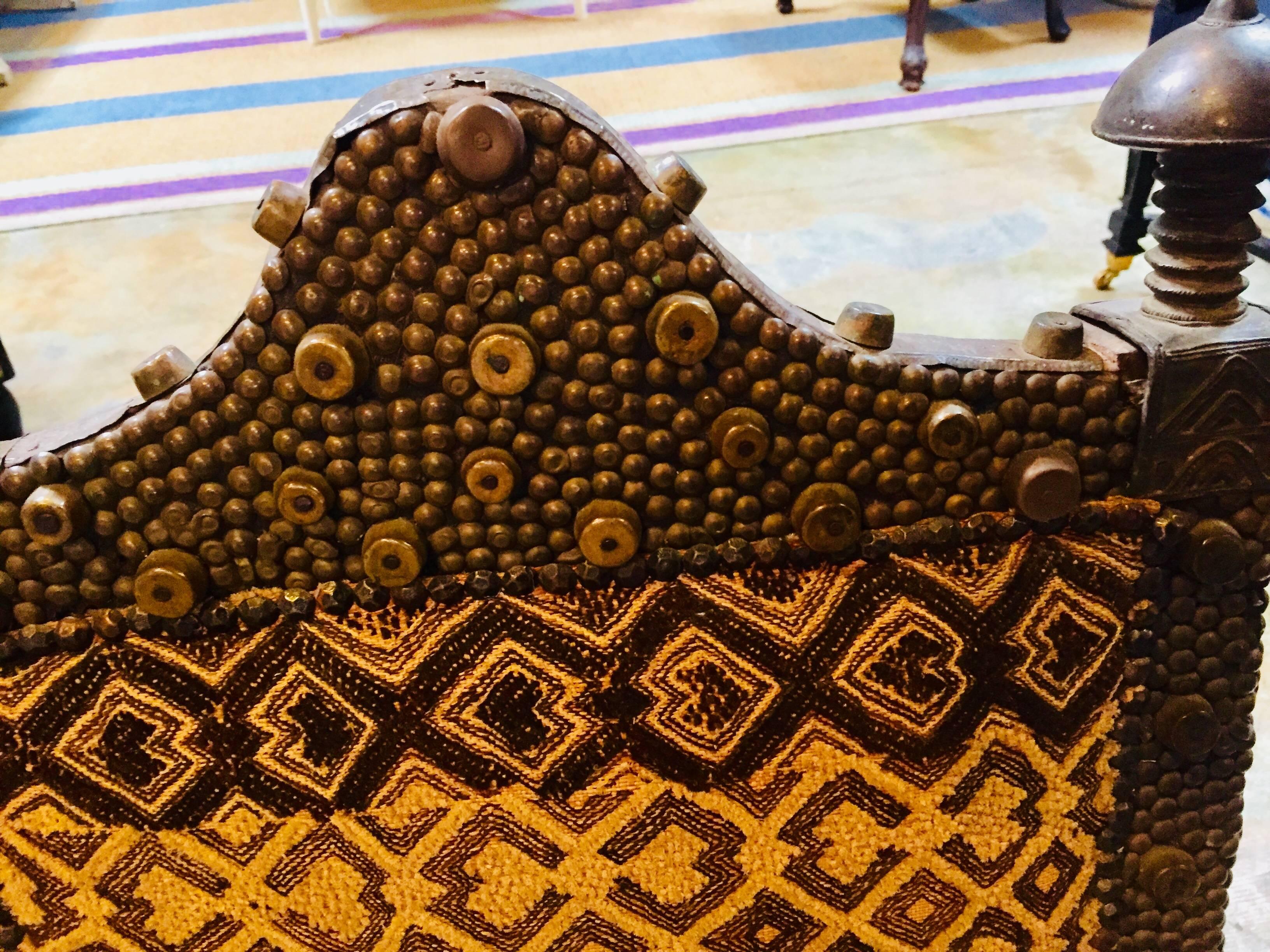 Exceptionnel fauteuil de roi datant d'environ 1860.
Travail du fer avec des pointes et des goujons de métier
Épis de faîtage en bronze
Textiles en tissu Kuba utilisés pour l'ameublement.