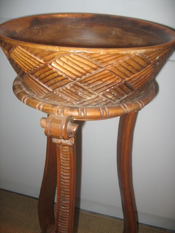 Hand-carved plant Stand with scrolled legs and feet. Container carved to look like a woven basket.