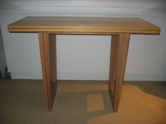 Midcentury console card table attributed to Paul Frankl. Modern folding style table with original finish. Opens to a dimension of 40 x 36 x 29 H. Hardware is brass.
 