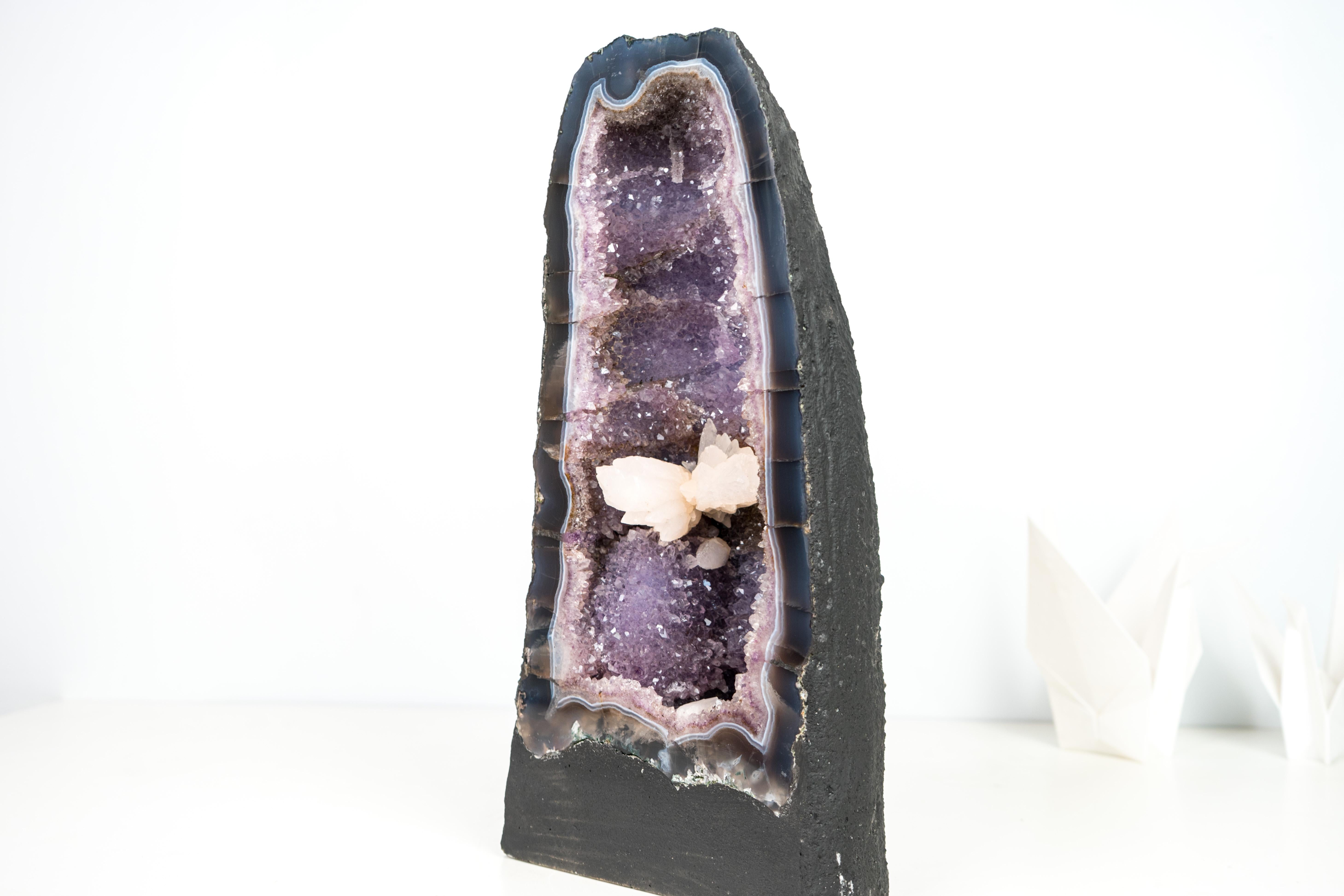Banded Agate Amethyst Geode Cathedral with a Rarely Seen UV-Reactive Calcite

▫️ Description

A geode that would be beautiful on its own, this piece is topped by a gemmy, large calcite that fluoresces a bright cobalt pink when exposed to UV light