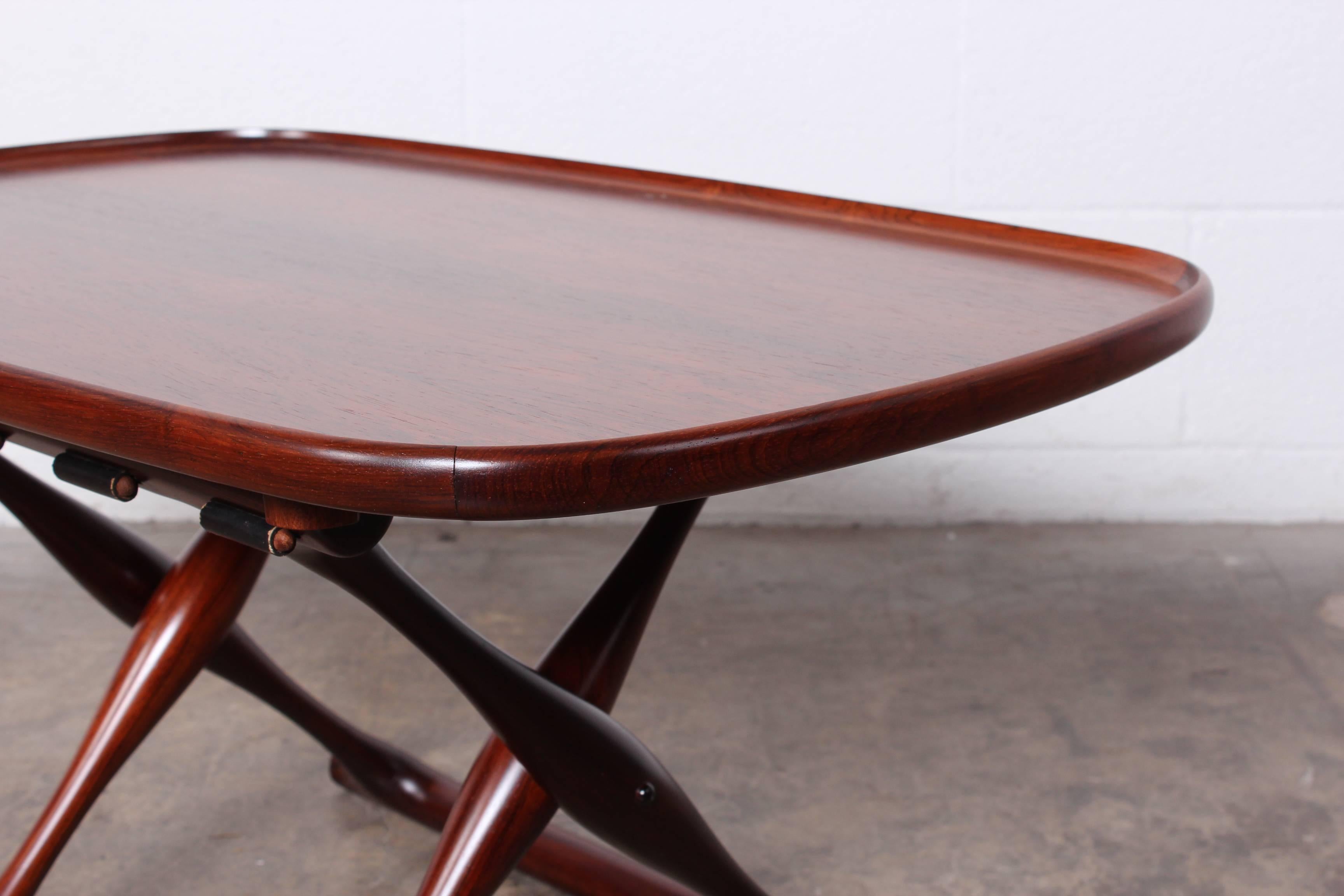 A solid rosewood Guldhoj folding stool with leather sling and detachable tray table. Designed by Poul Hundevad.