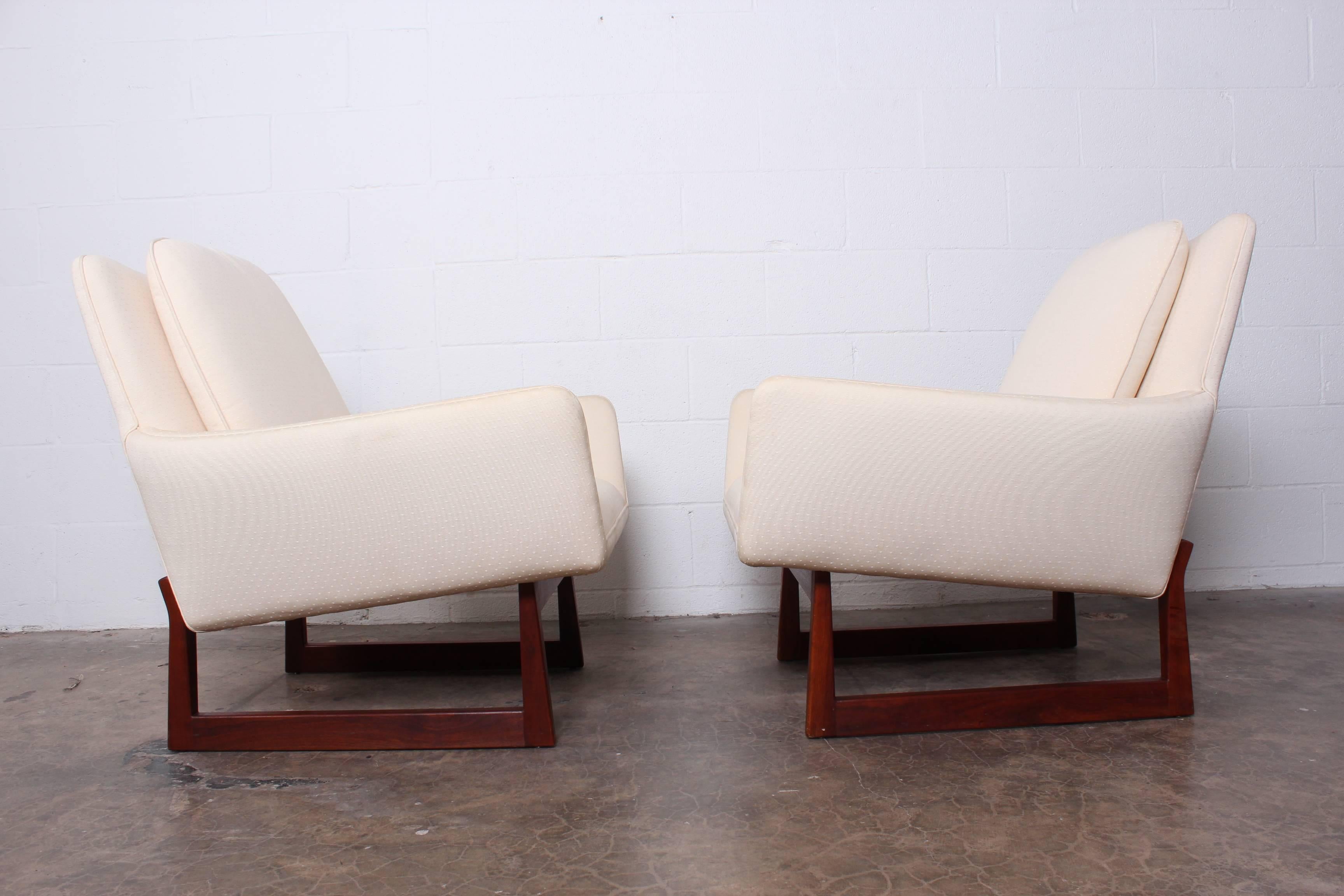 A pair of lounge chairs with walnut bases. Designed by Jens Risom.