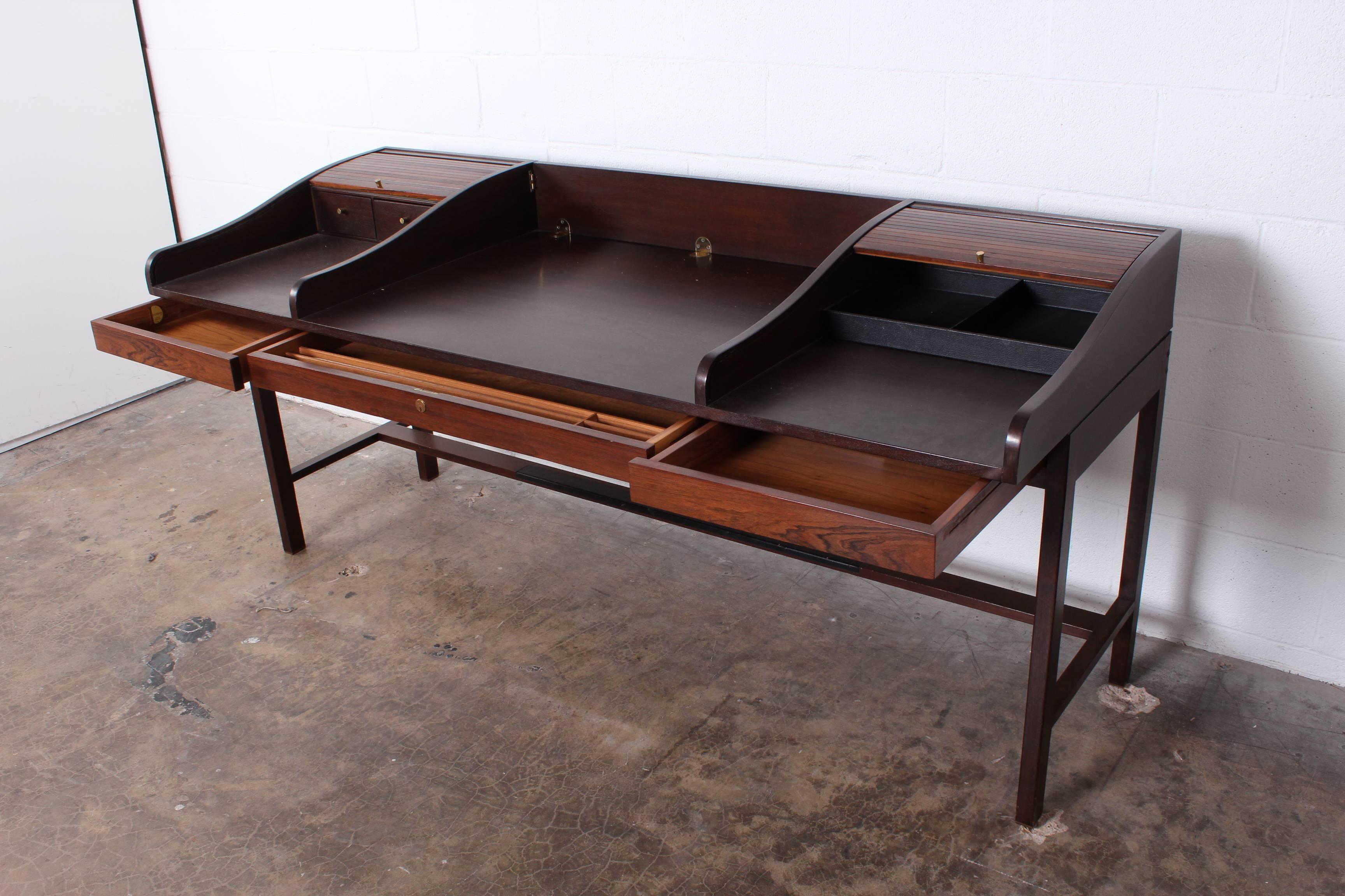 A rosewood tambour roll top desk with brass feet and leather trim. Designed by Edward Wormley for Dunbar.