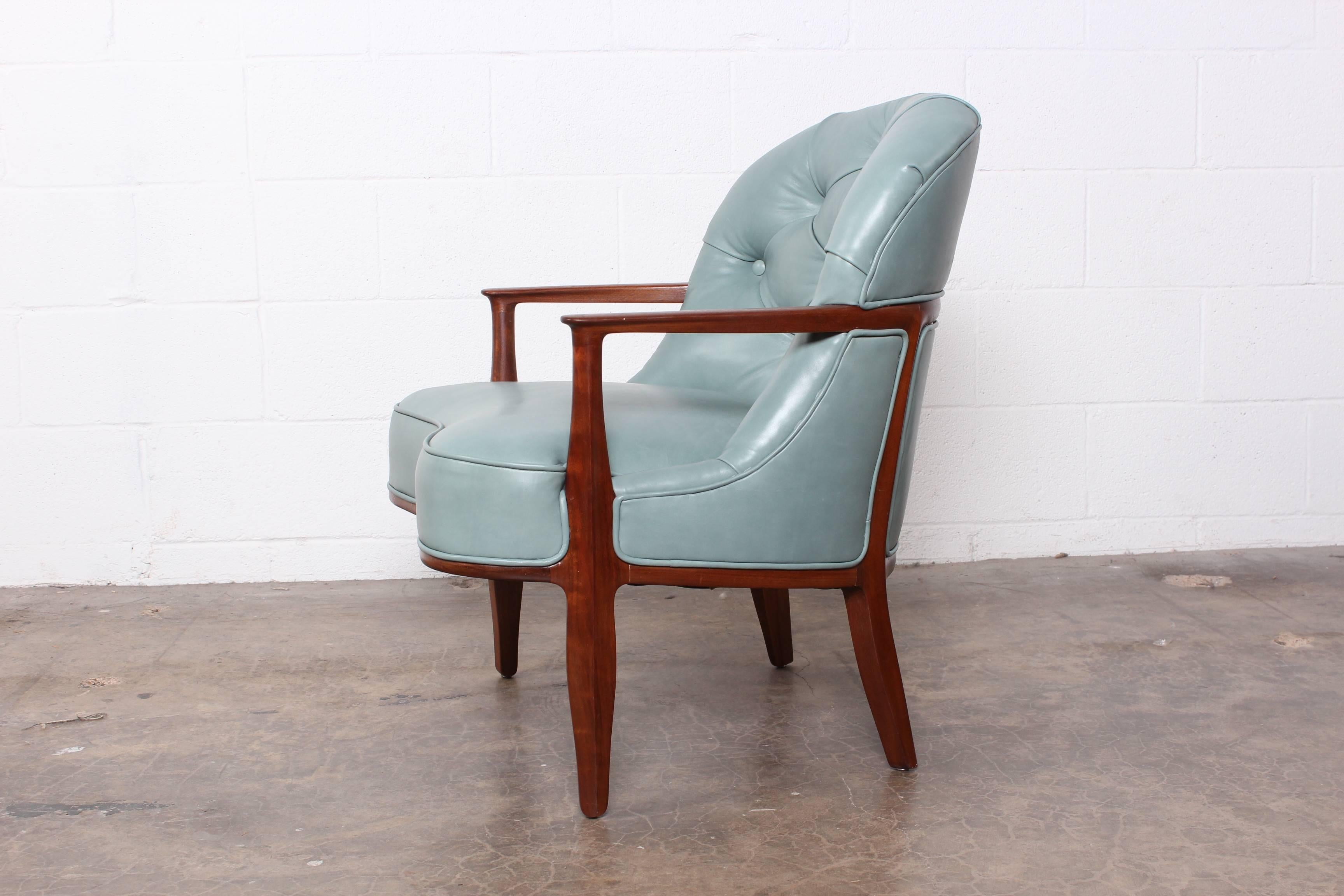 A walnut Janus lounge chair upholstered in blue leather. Designed by Edward Wormley for Dunbar.