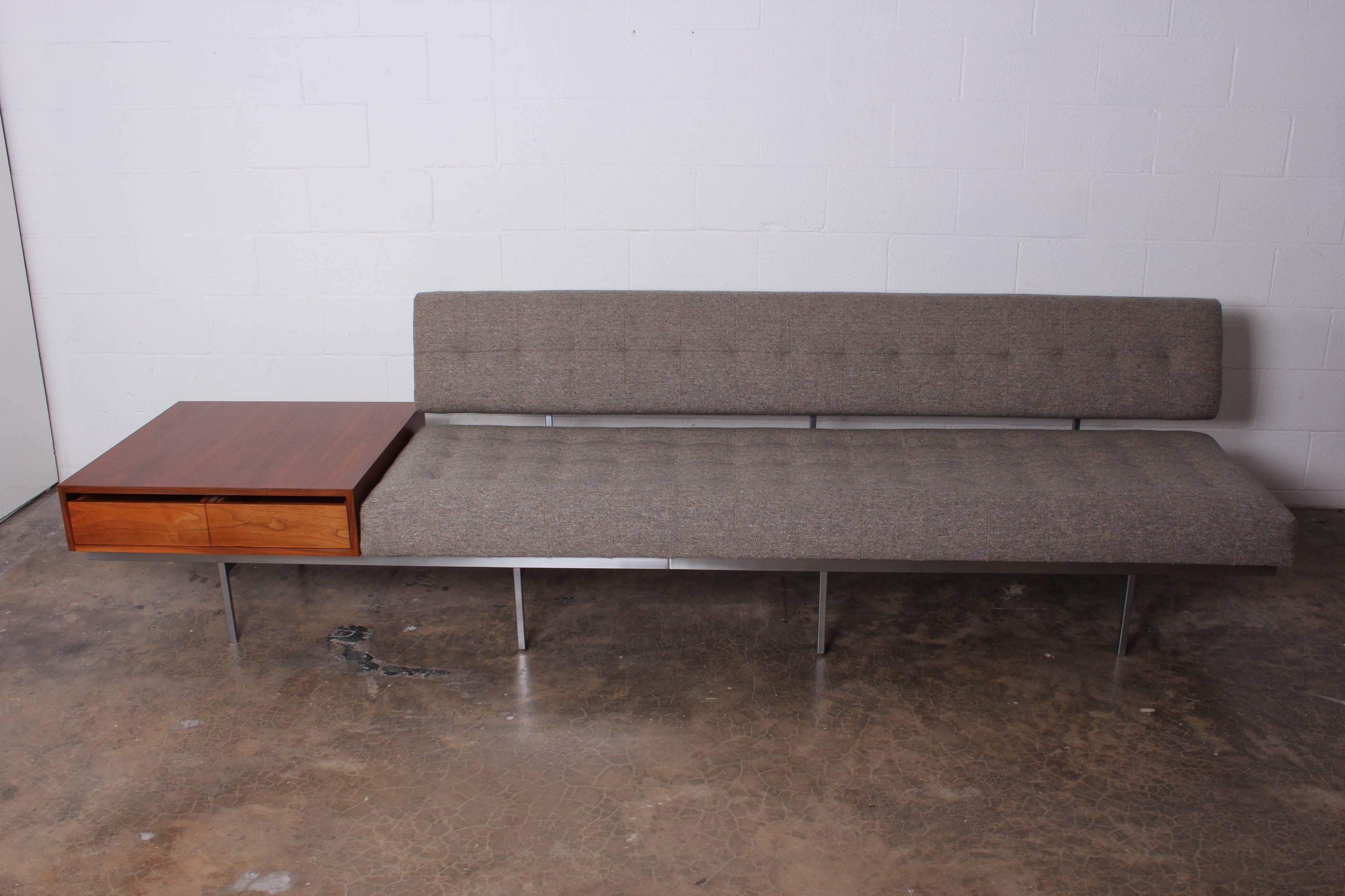An early Florence Knoll designed sofa with brushed steel frame and attached walnut cabinet with drawers. Fully restored and reupholstered in Maharam wool.
